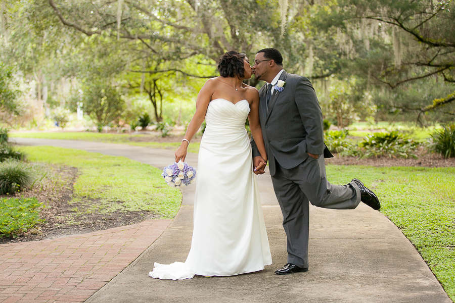 Bride and groom kissing and groom kicking his leg up