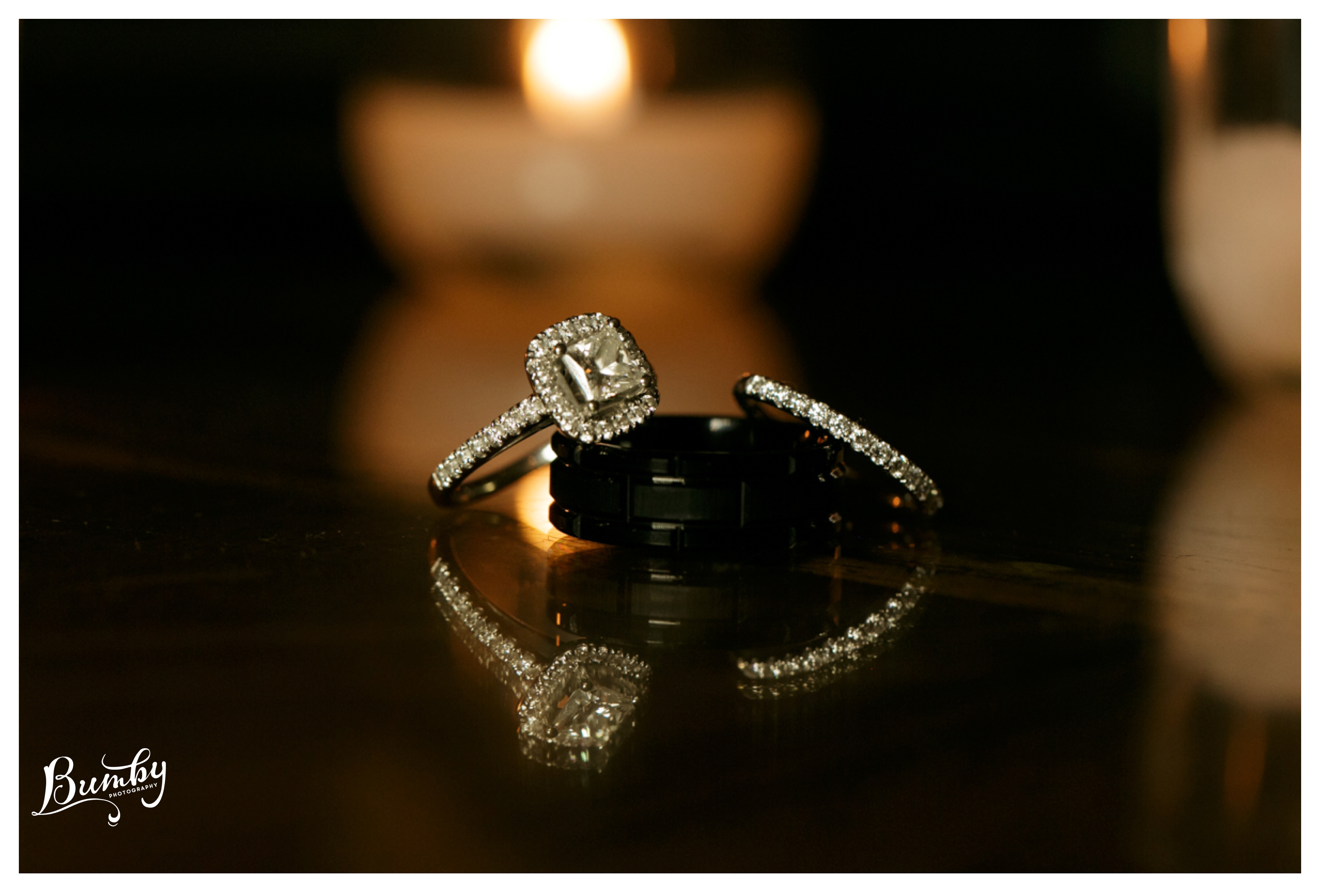 square diamond wedding ring reflecting on glass