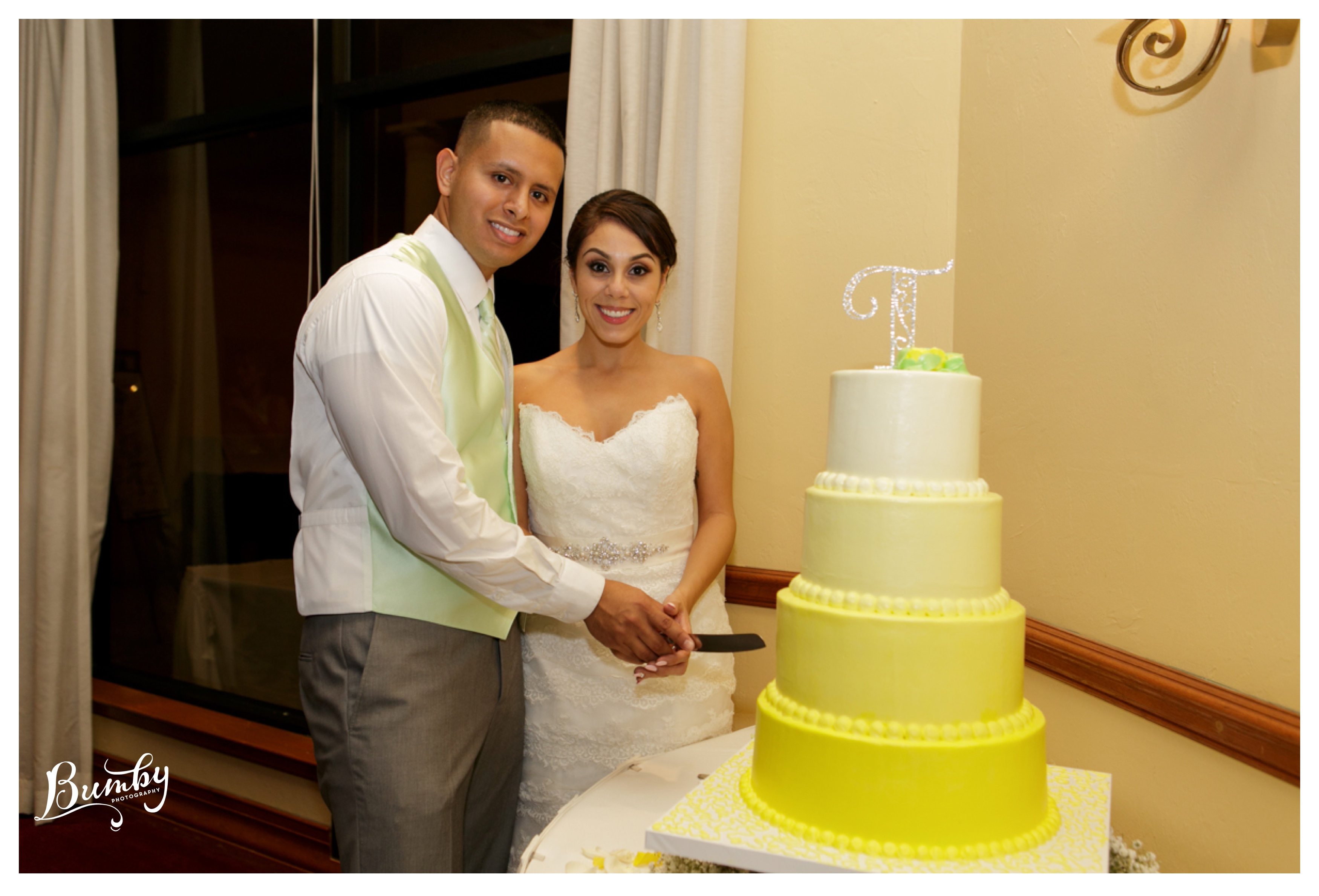 bride and groom smiling with yellow ombre cake