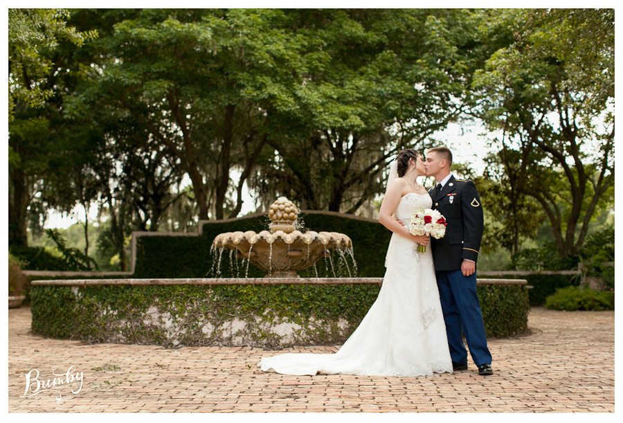 bride and groom kissing by fountain
