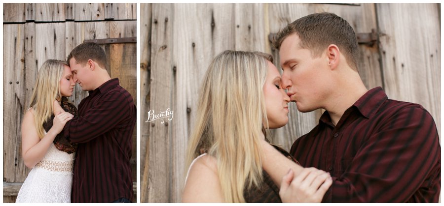 couple kissing and snuggling on rustic wall