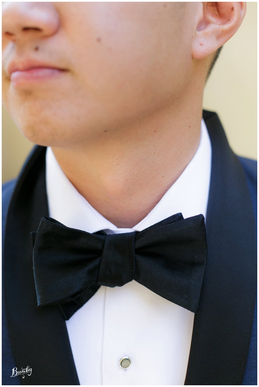 Close shot of the grooms black bowtie.