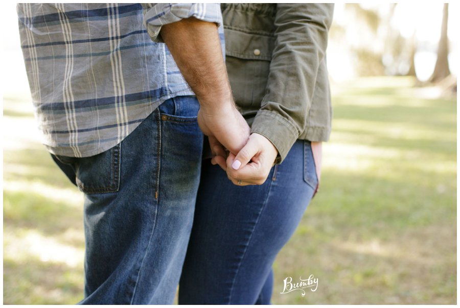 Engaged couple holding hands while outdoors.