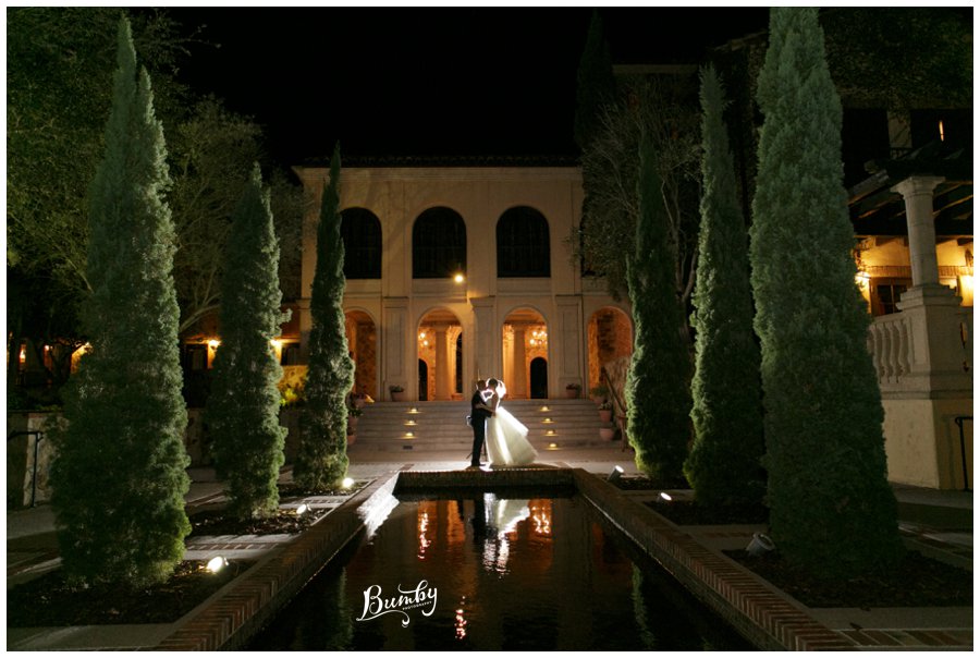Bride and groom taking a night photo at the Bella Collina reflection pond.