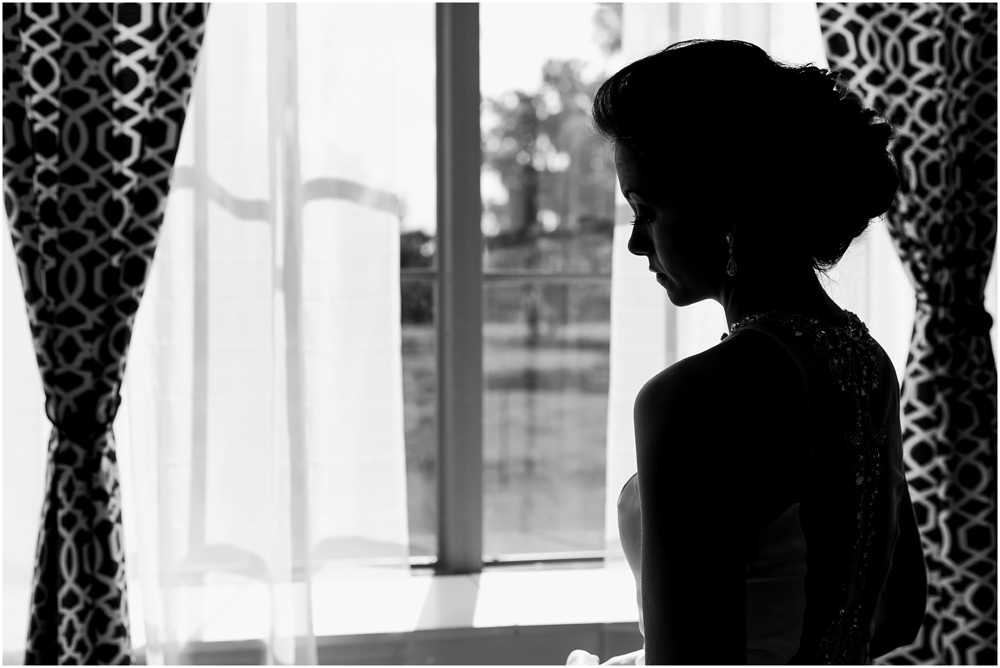 Silhouette of bride standing at window at Rocking H Ranch.