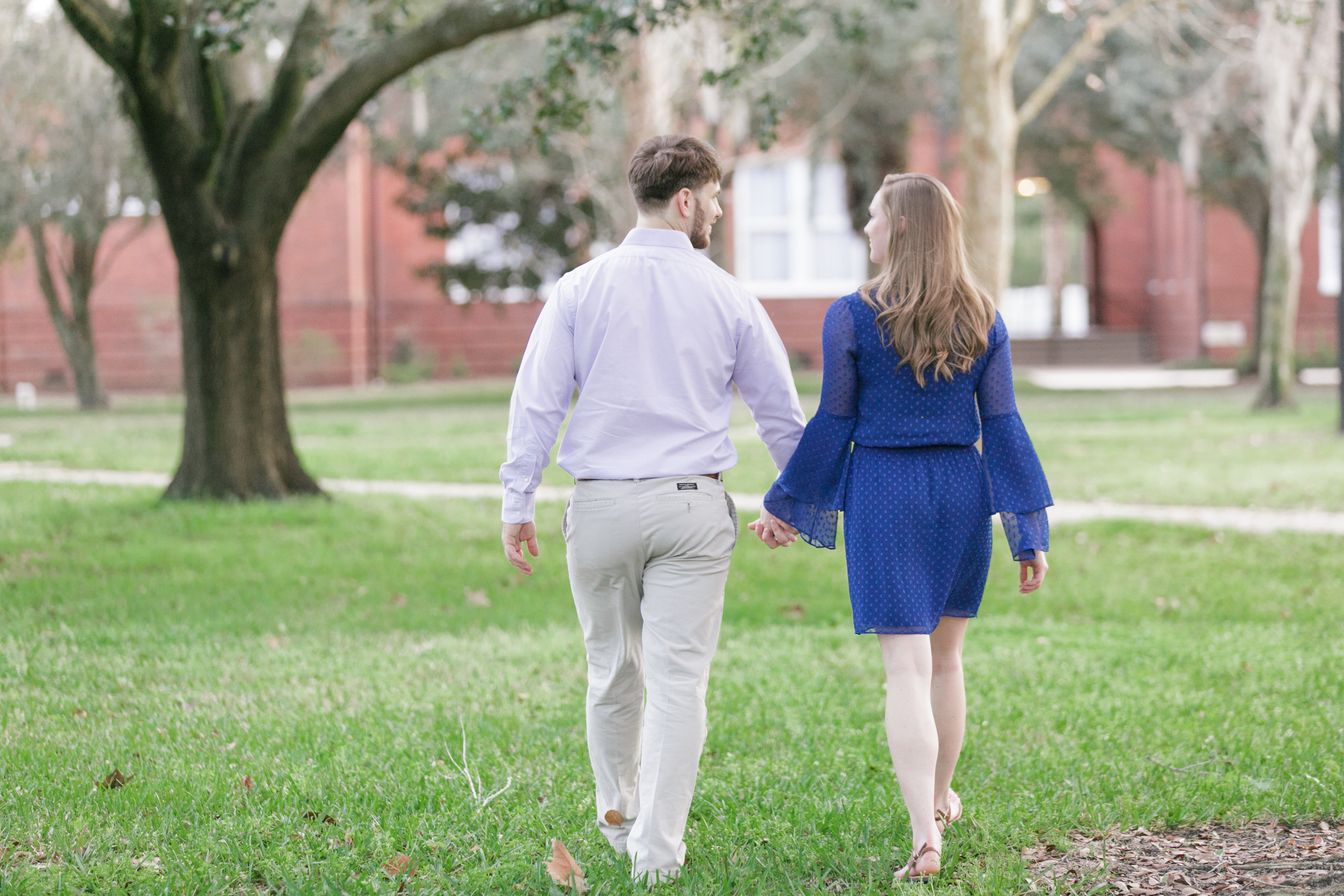 Engagement session couple holding hands and walking through Downtown Sanford