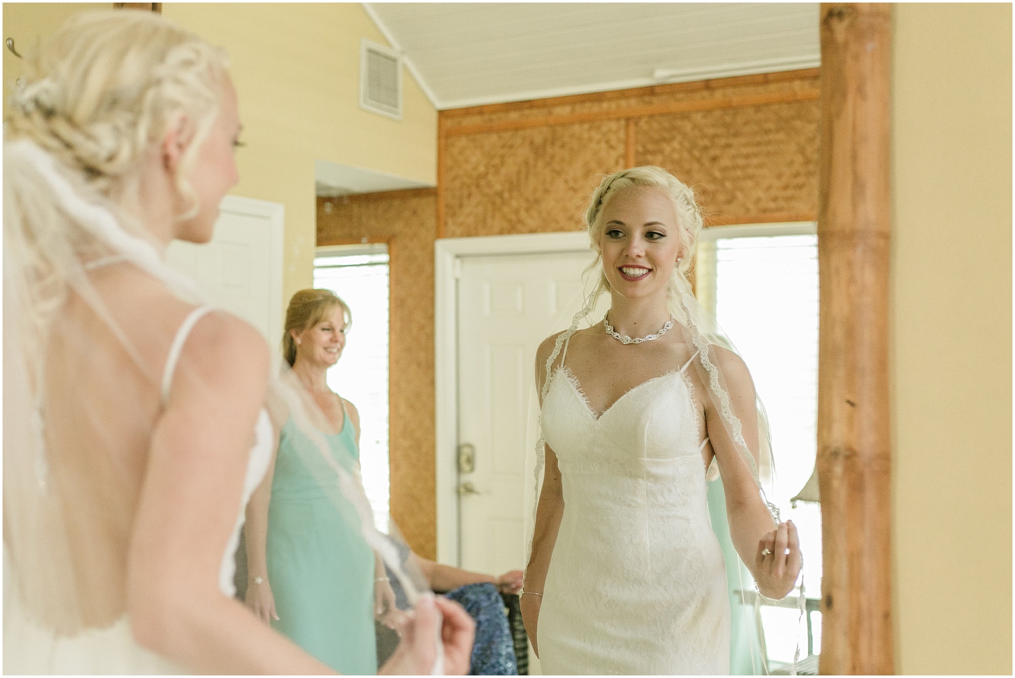 Bride looks at herself in the mirror before getting married.