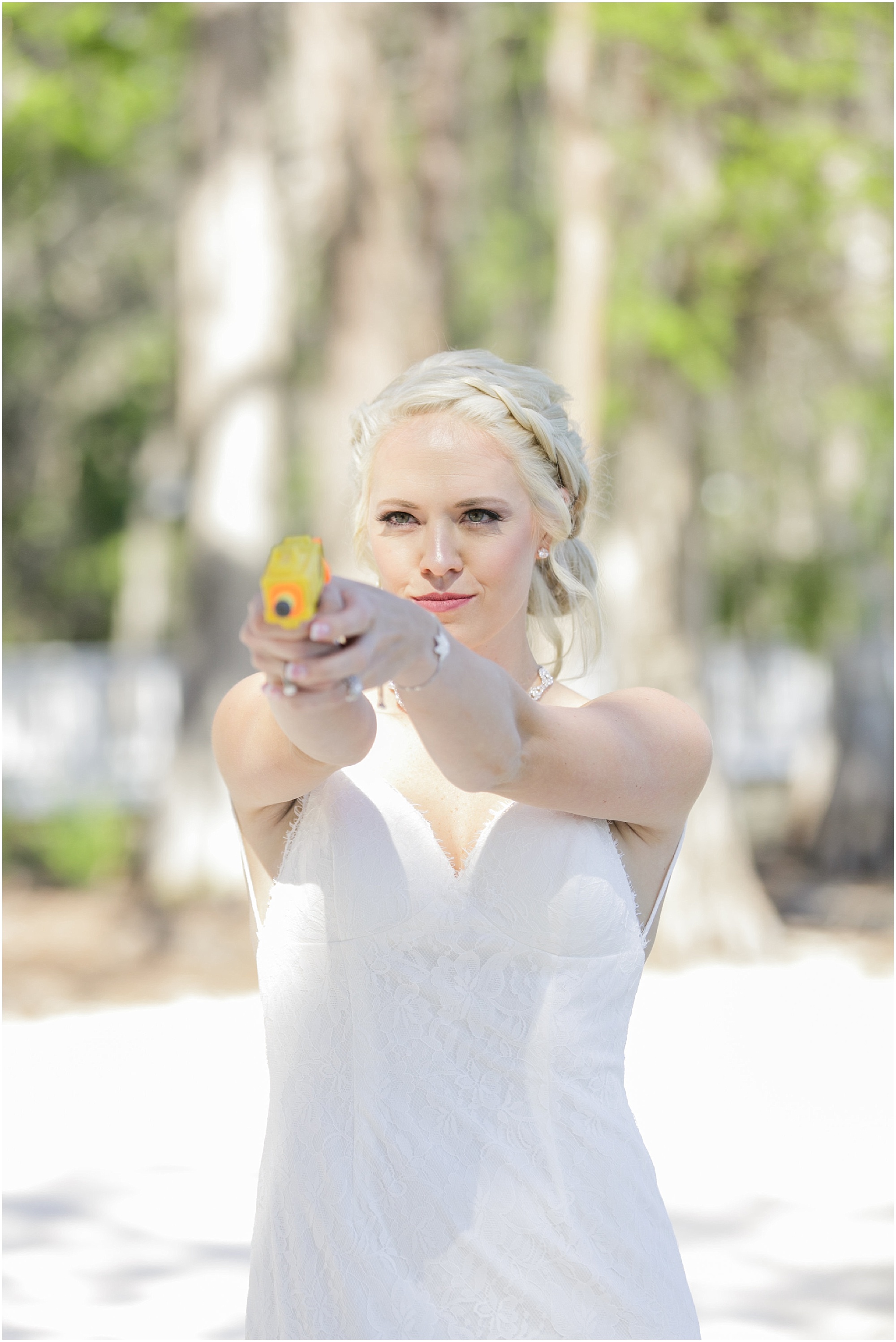 Bride getting ready to fire a nerf gun at groom during first look.