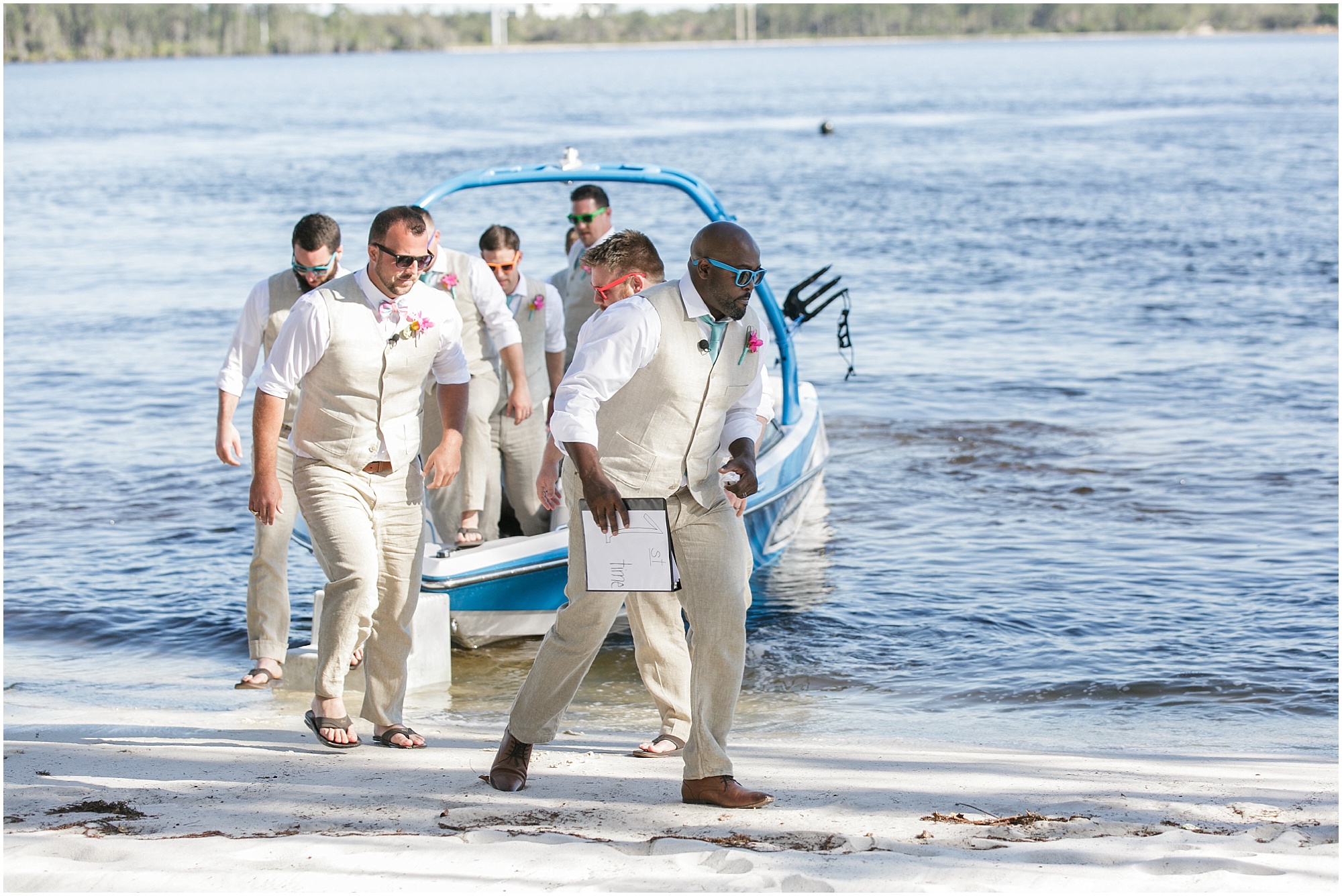 Groomsmen exiting boat on shoreline. 