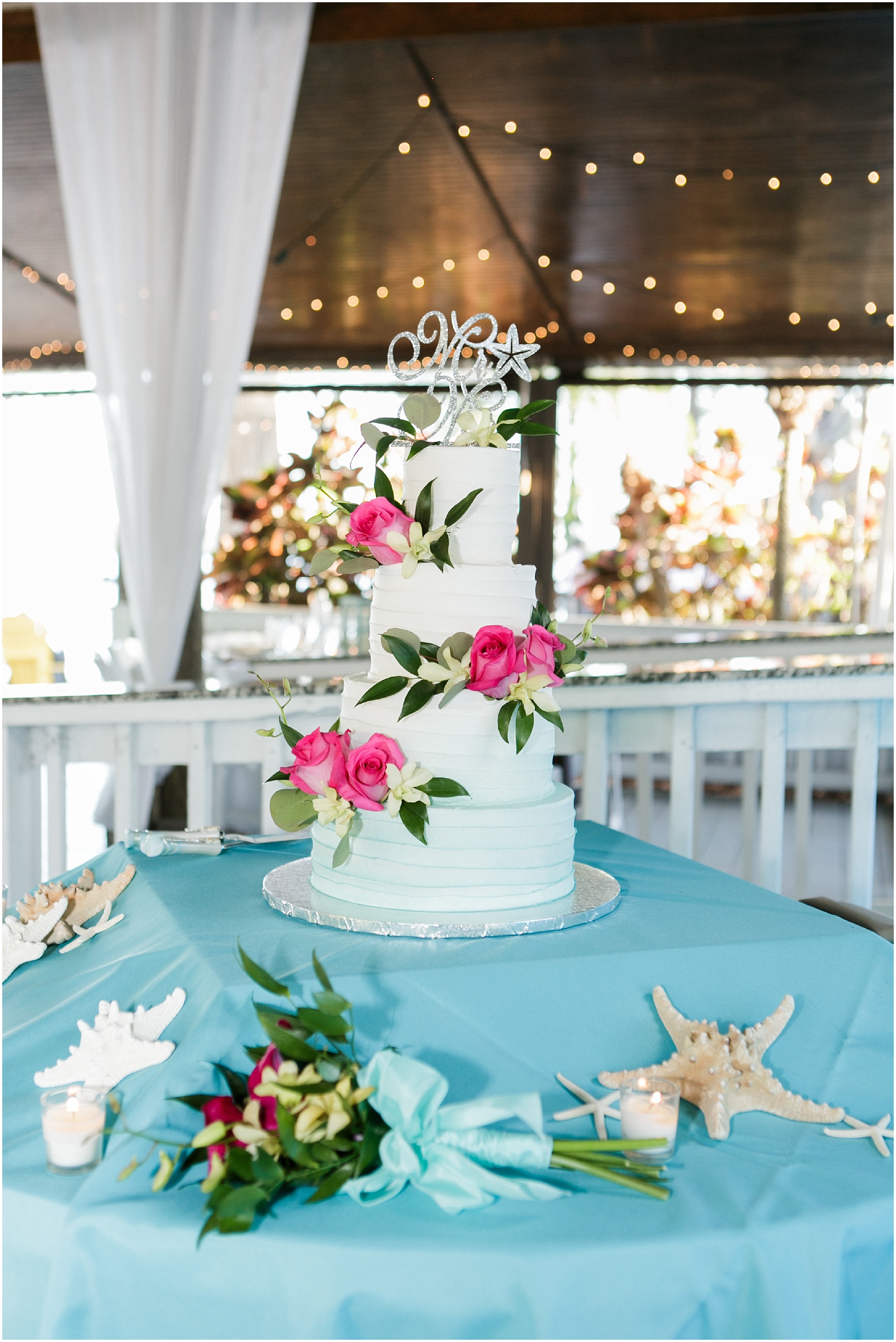 4-tier wedding cake with pink and green floral accents. 