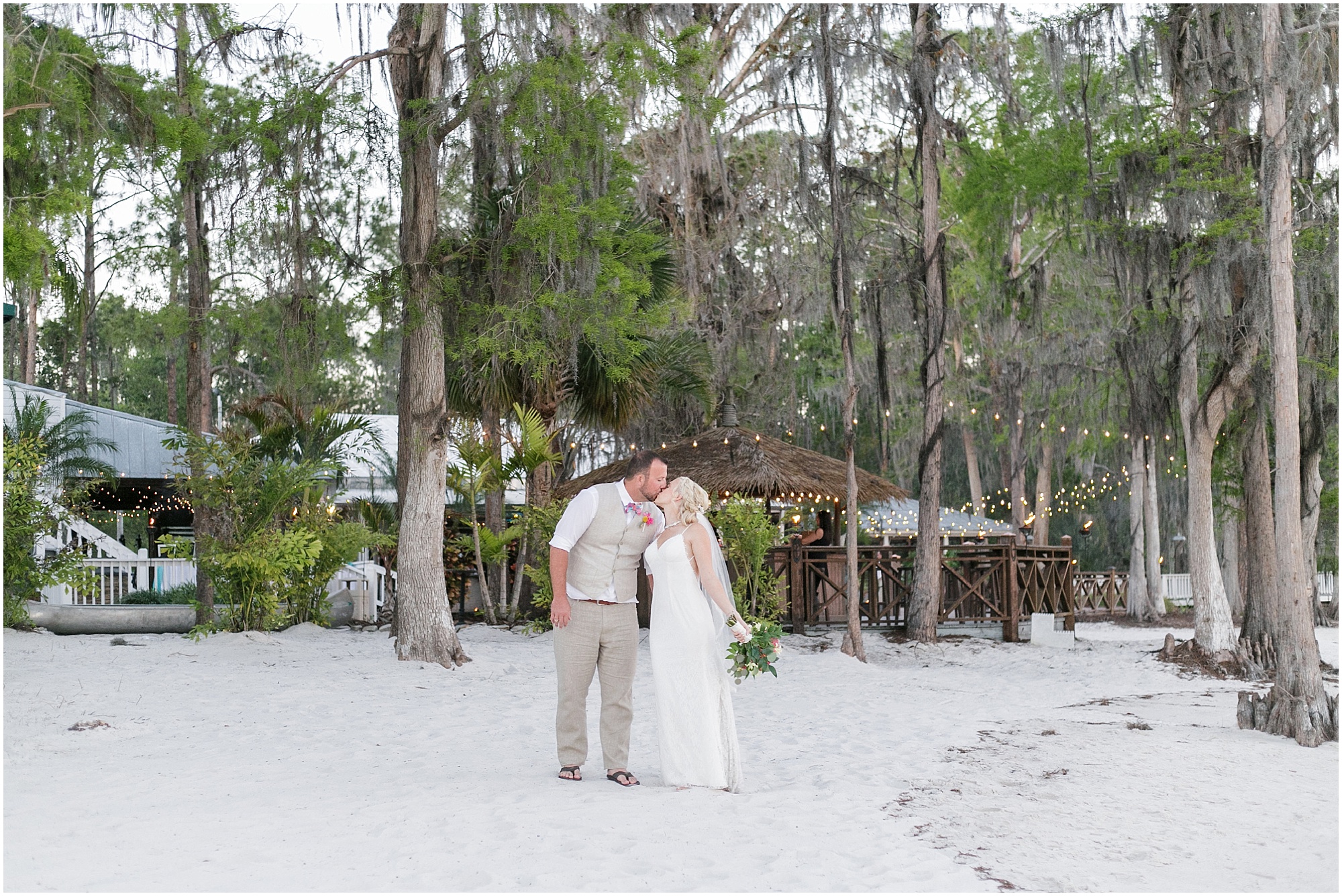 Bride and groom kiss on the beach.