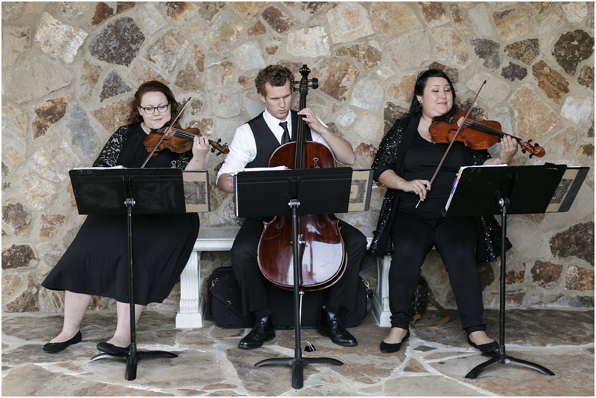 A violinist, violist, and cellist playing music during the ceremony. 
