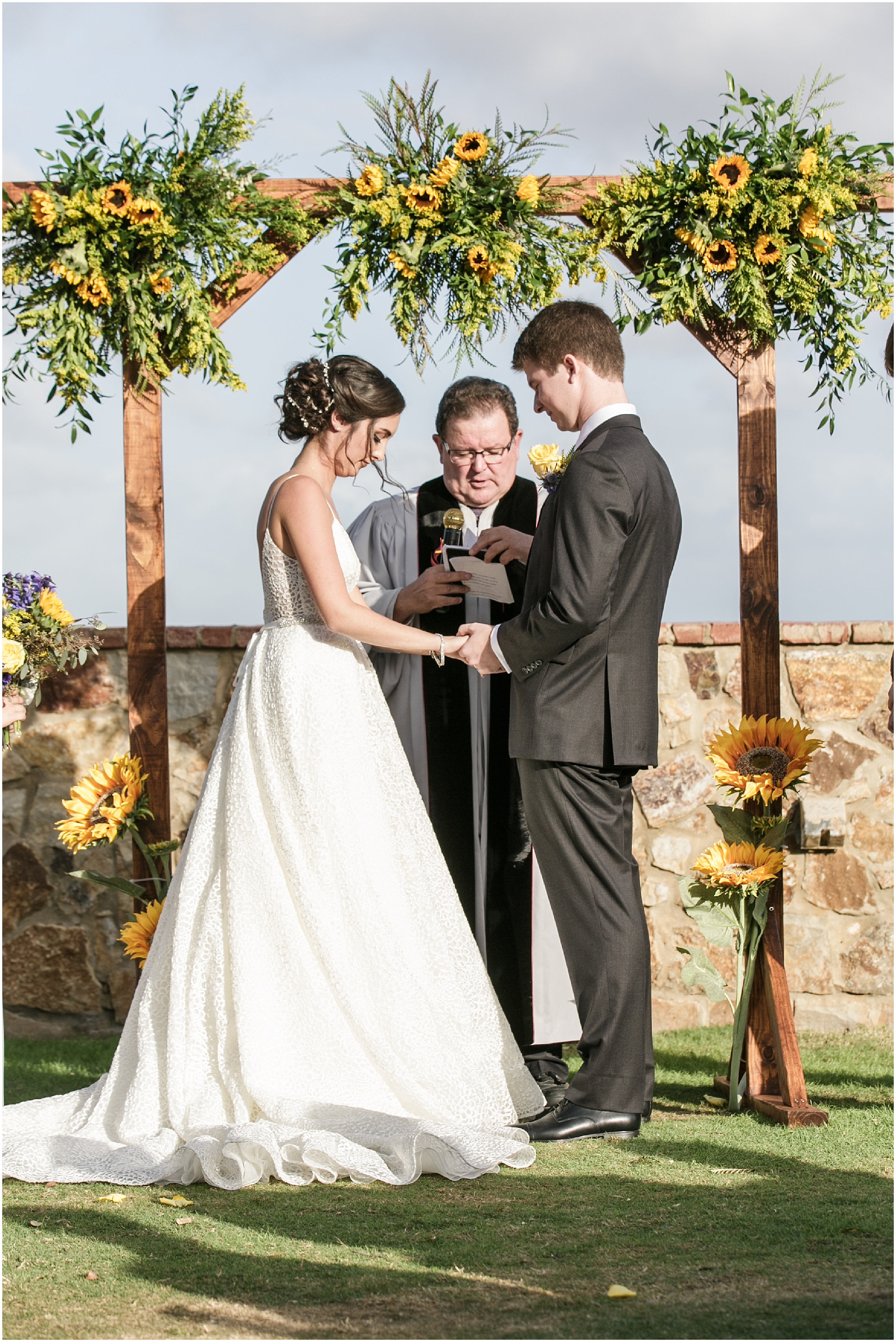 Bride and groom praying during their autumn sunflower wedding.