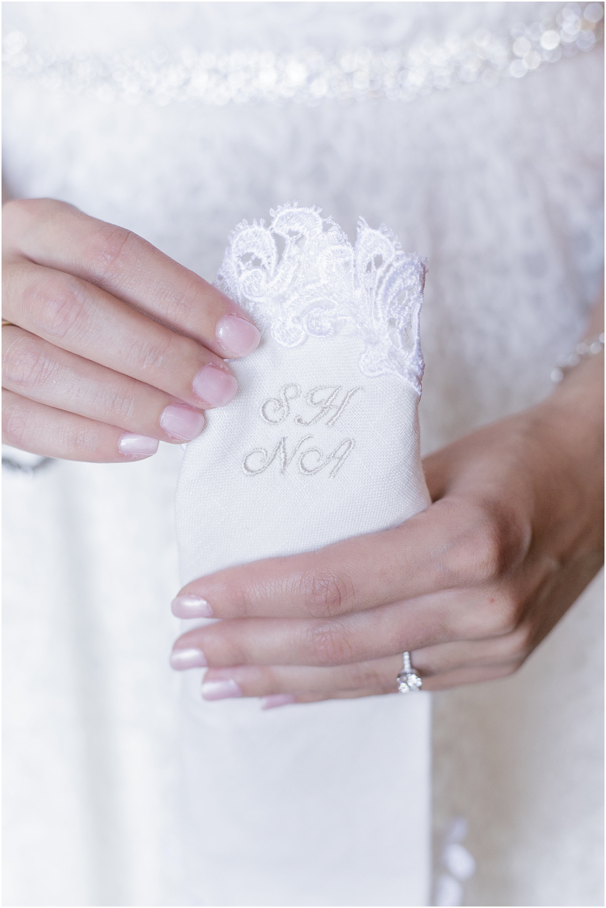 White handkerchief with bride and grooms initials embroidered in it. 