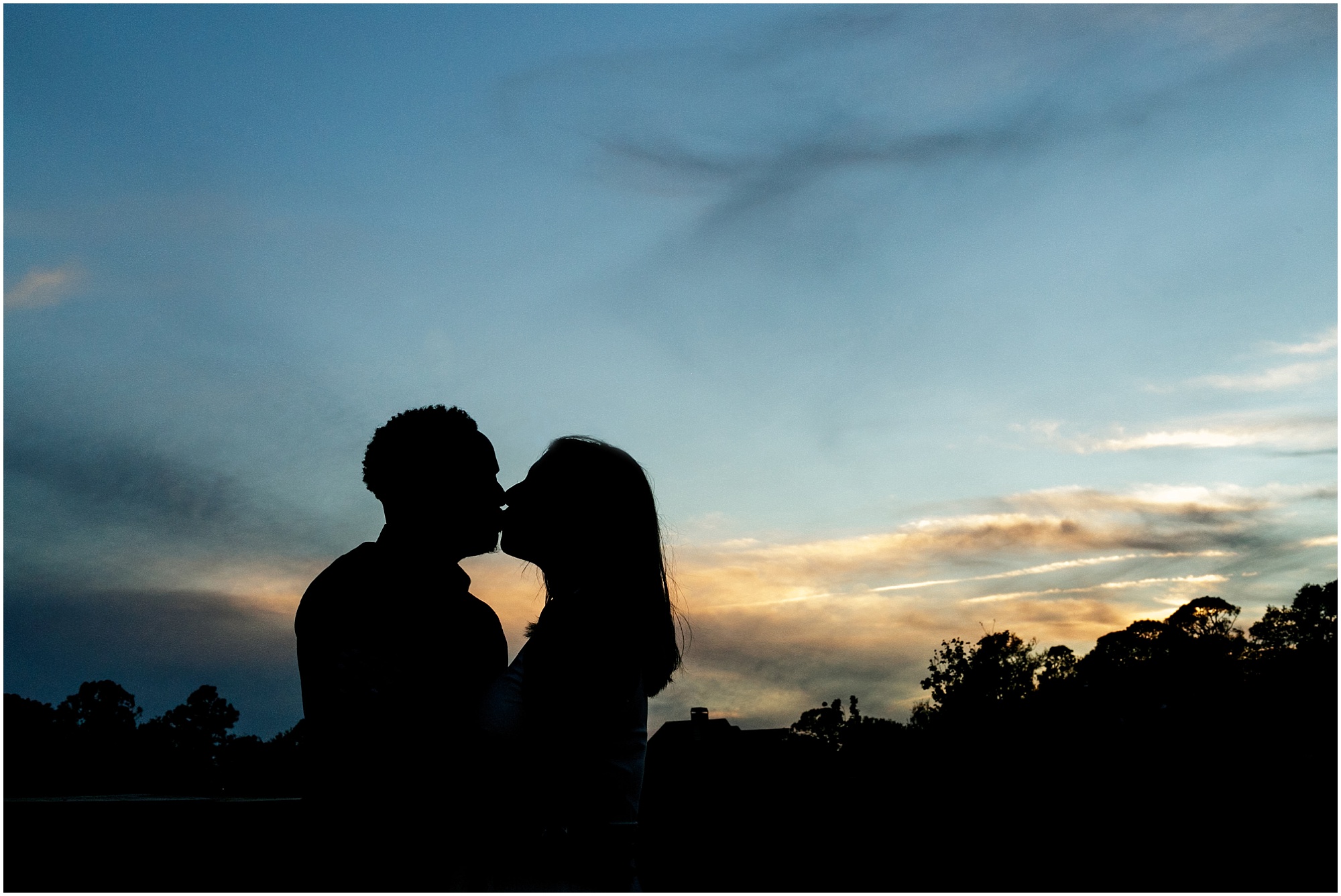 Lake Nona Engagement couple Jodie and James kissing while the sunsets behind them. 