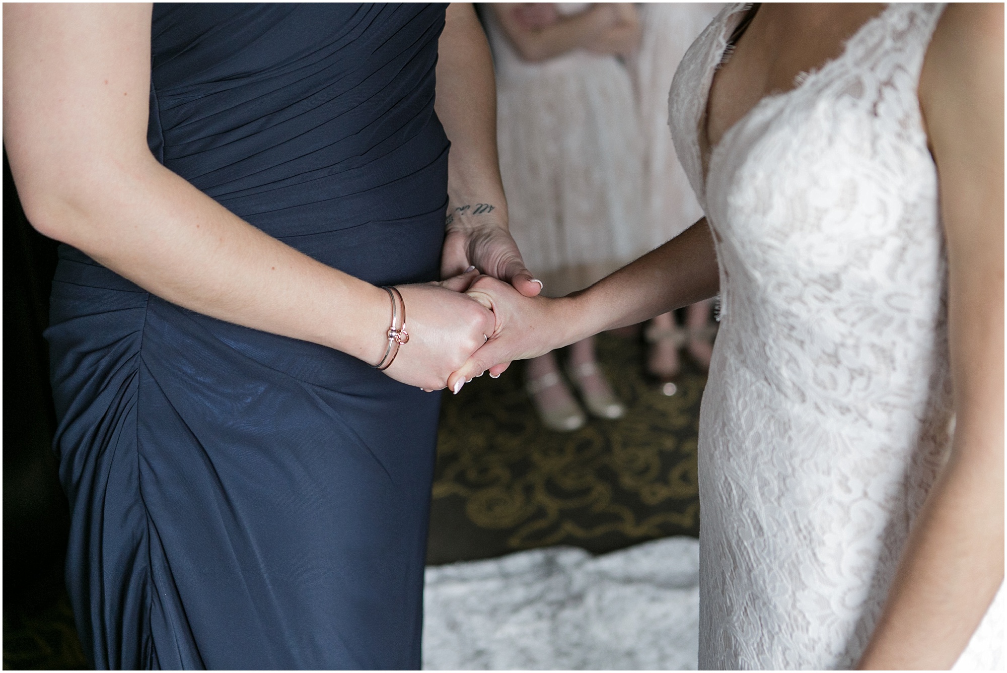 Bride holding the hand of her sister who is also her maid of honor.