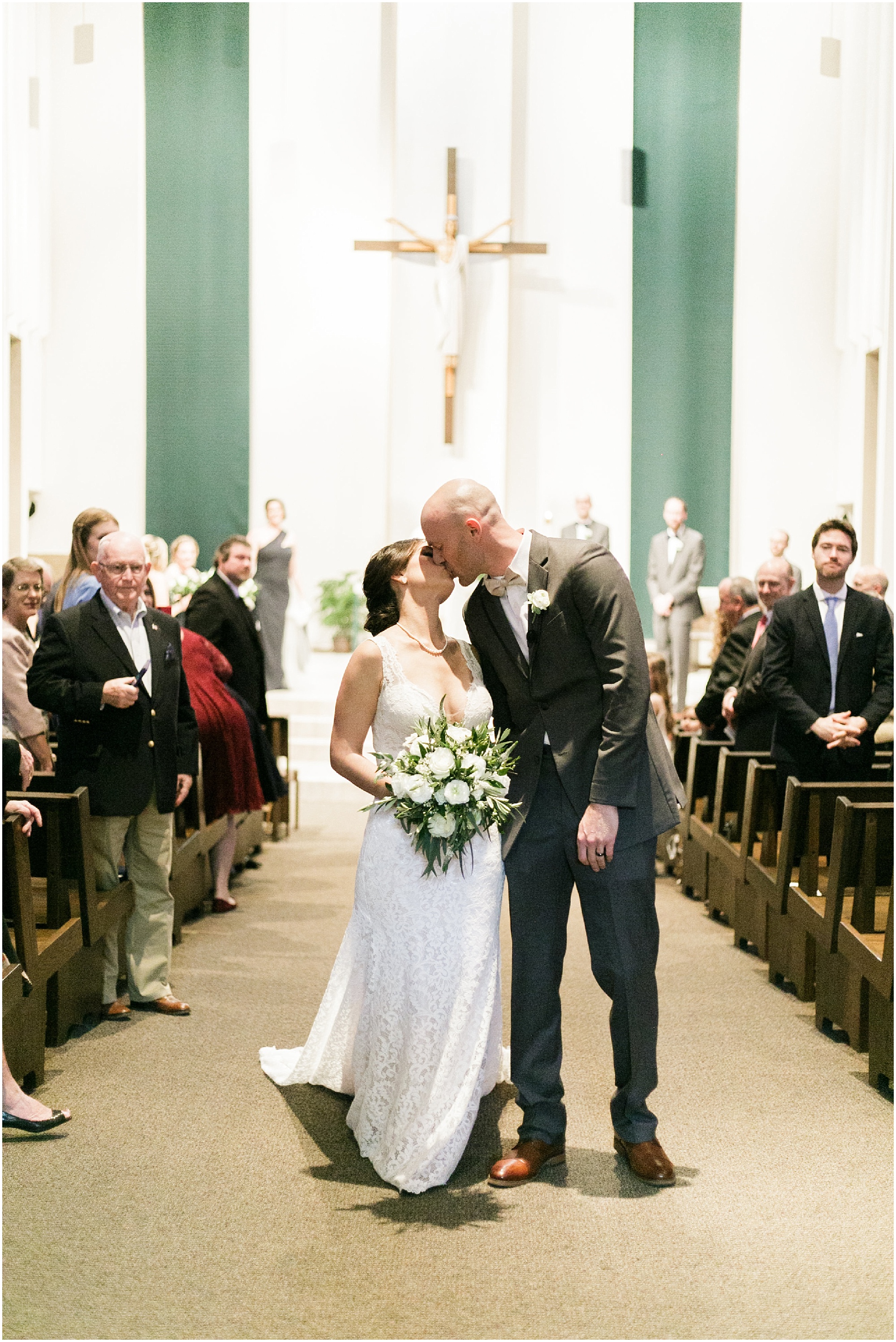 Newley wedded couple kisses at the end of the aisle after getting married.