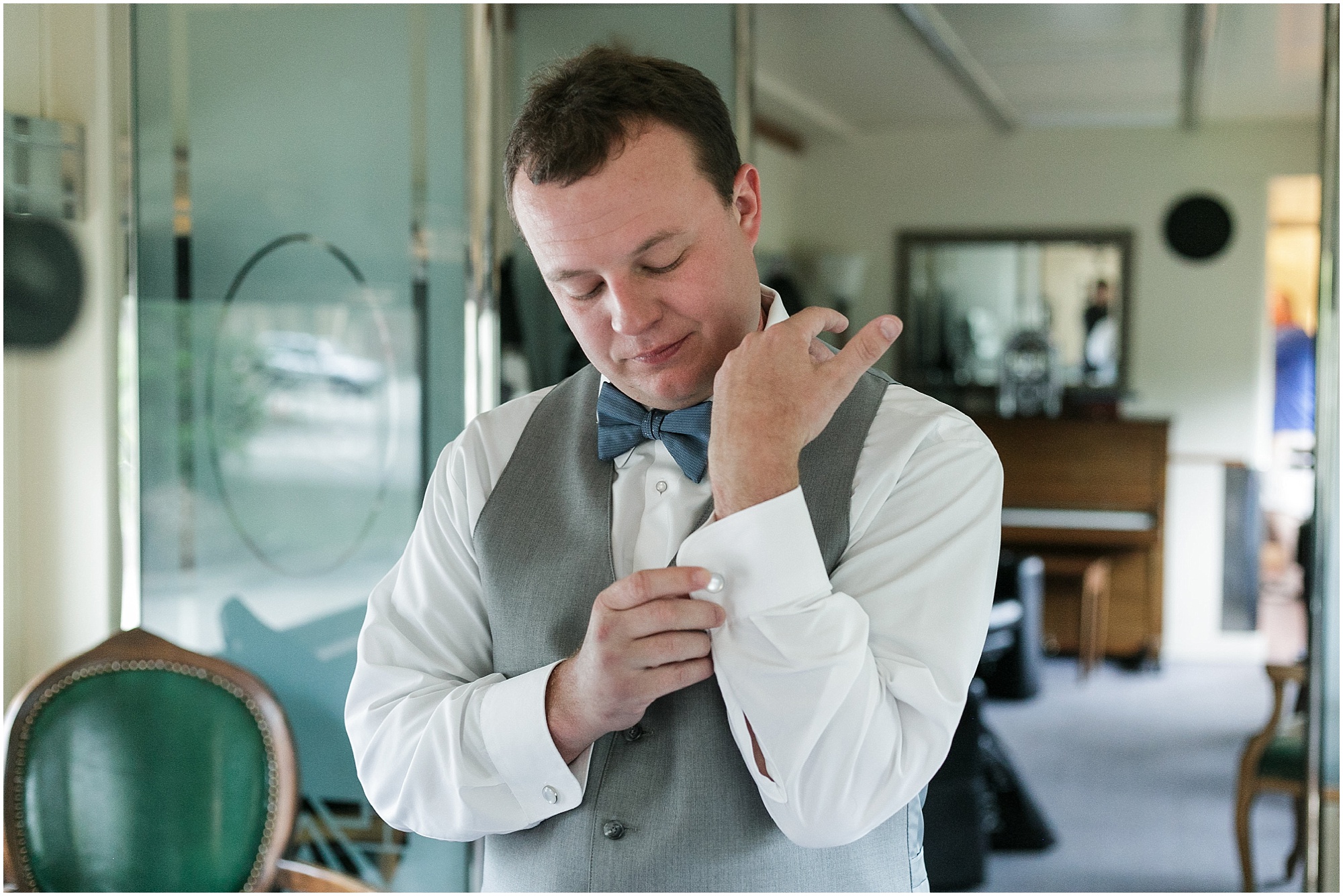 Groom putting on his cufflinks as he gets ready for his wedding.