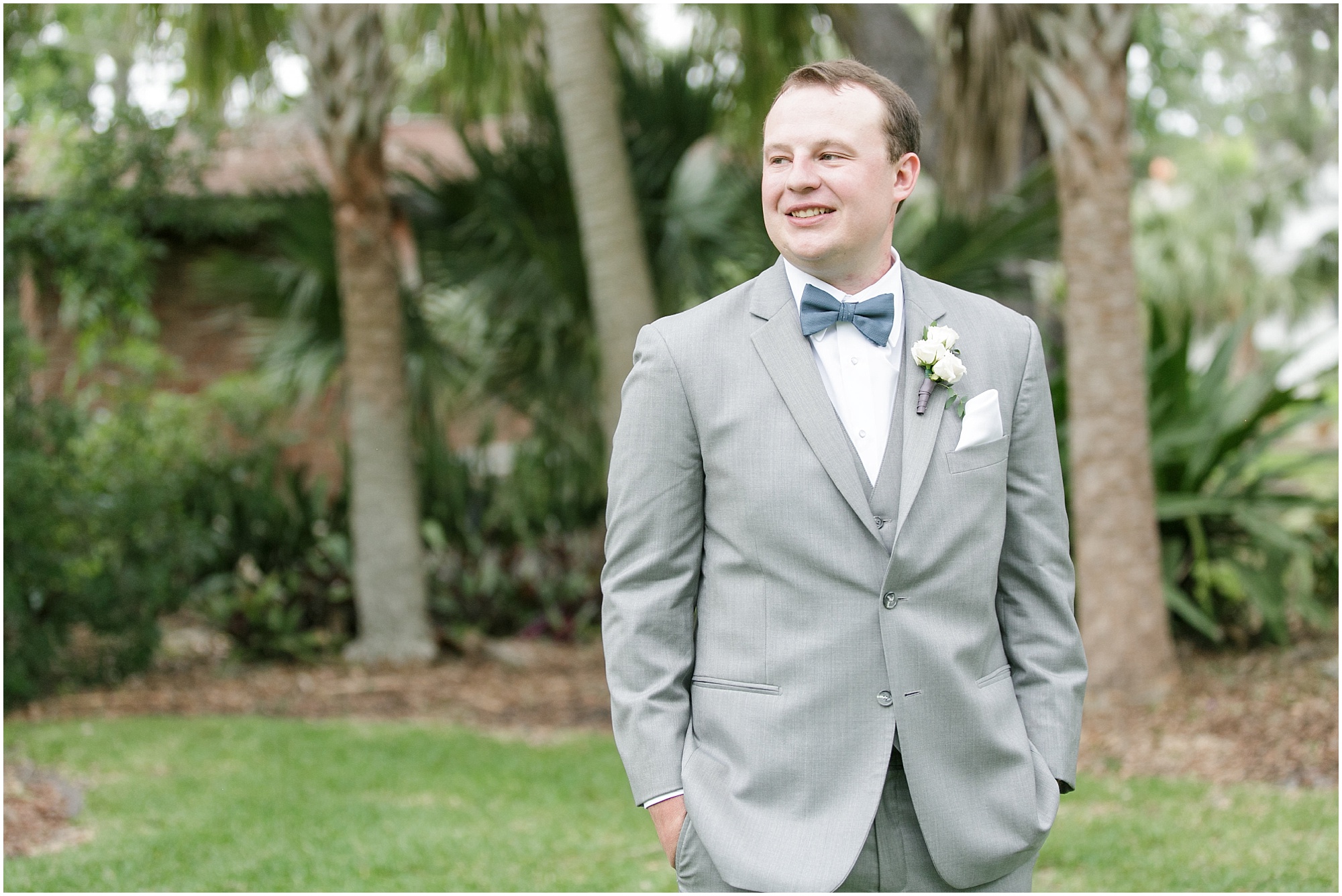 Groom standing among trees at wedding venue in Central Florida.