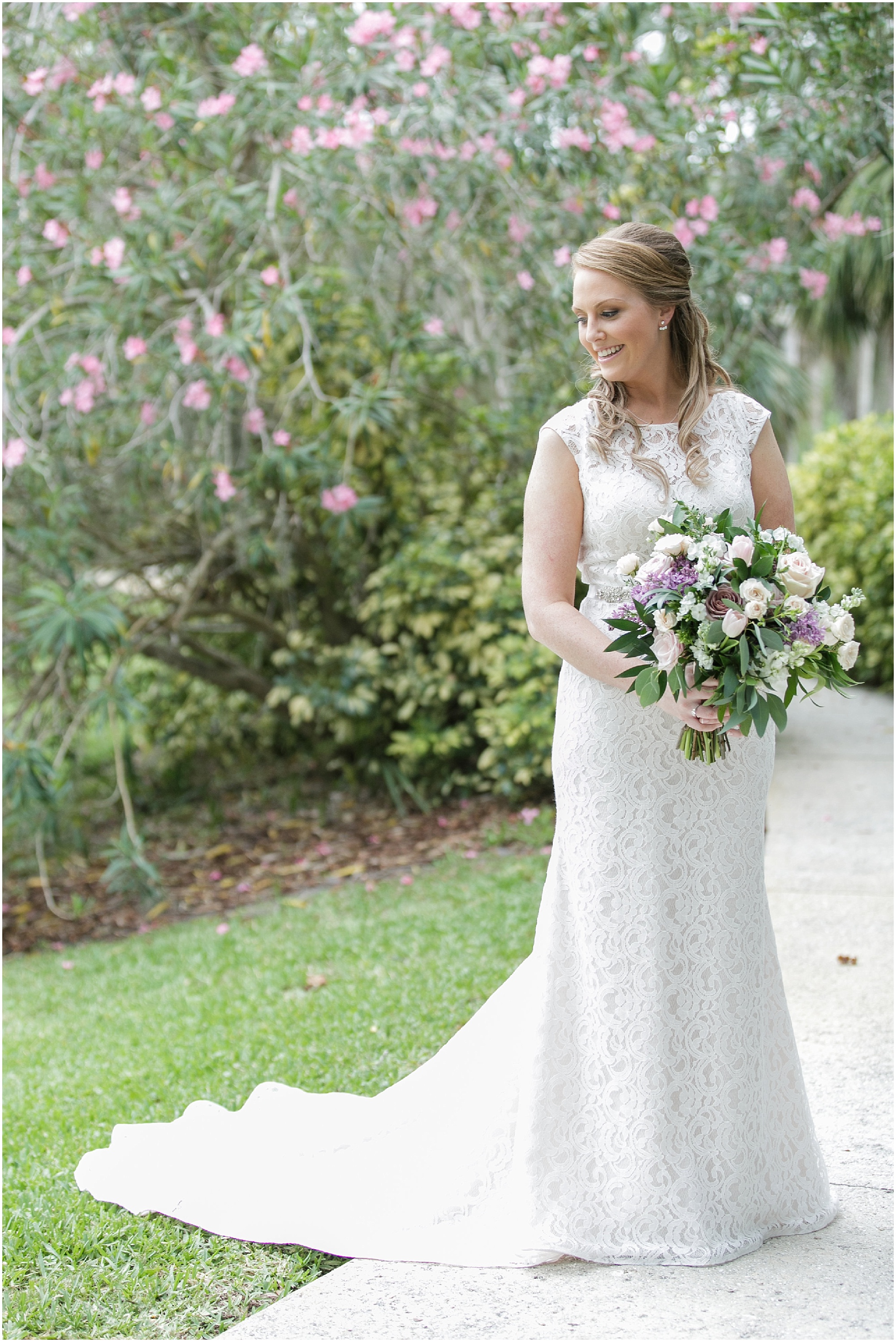 Full photo of a bride standing in the garden in her white wedding dress.