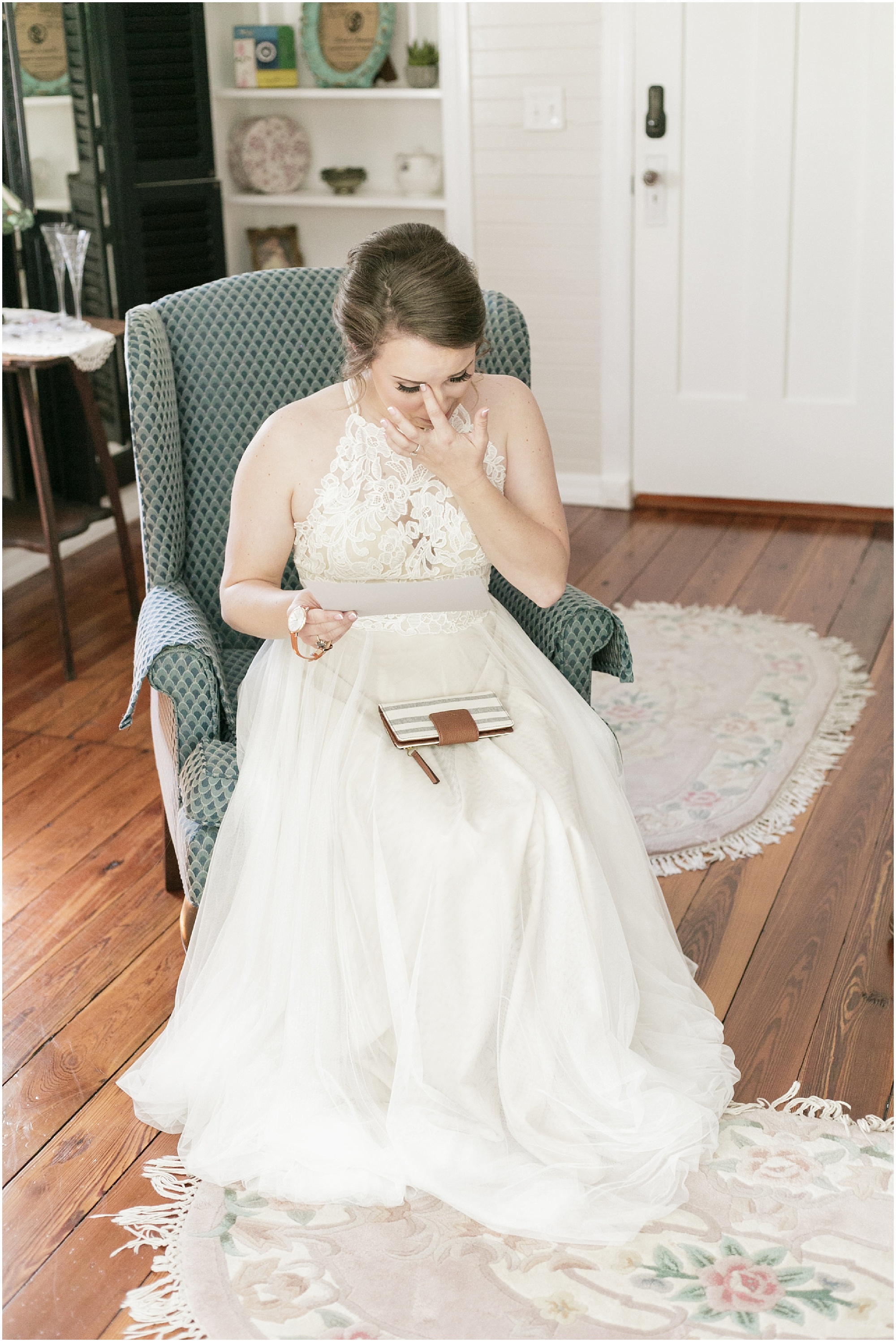 Bride wiping her tears away as she reads a love note from her groom.