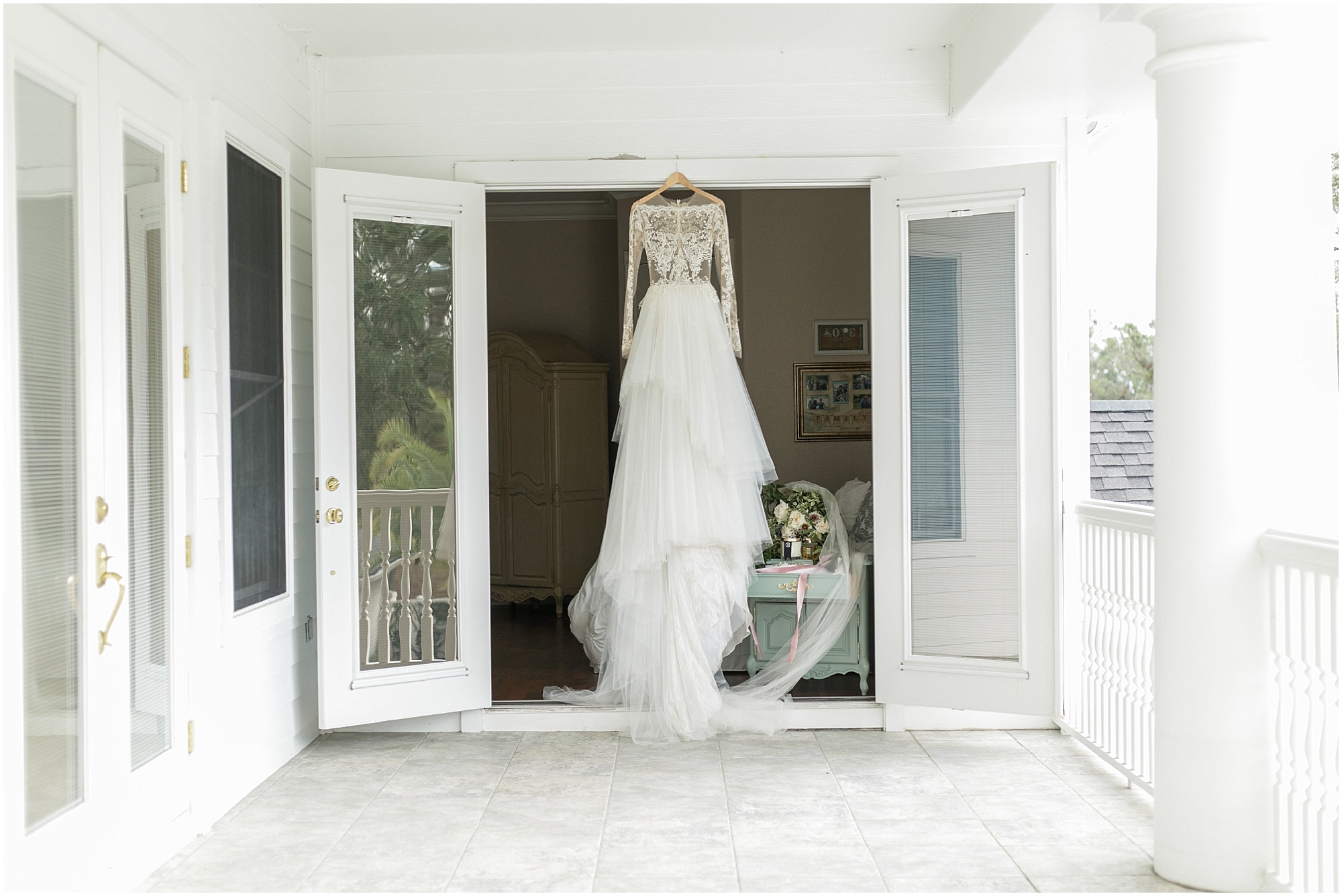 Timeless southern bride's wedding dress hanging on the door outside.