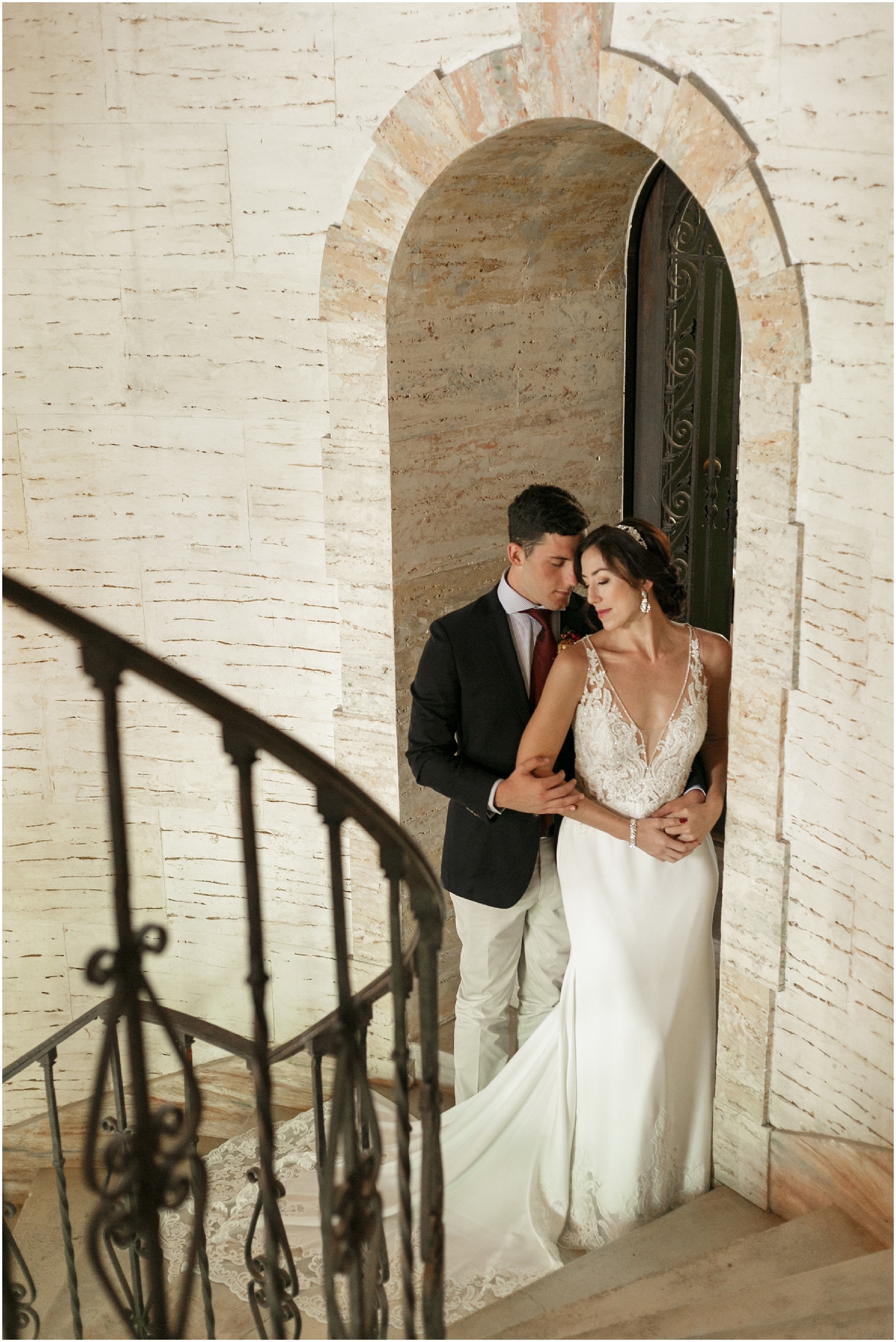 Couple holding each other in an alcove of the entryway stairs at the Howey Mansion
