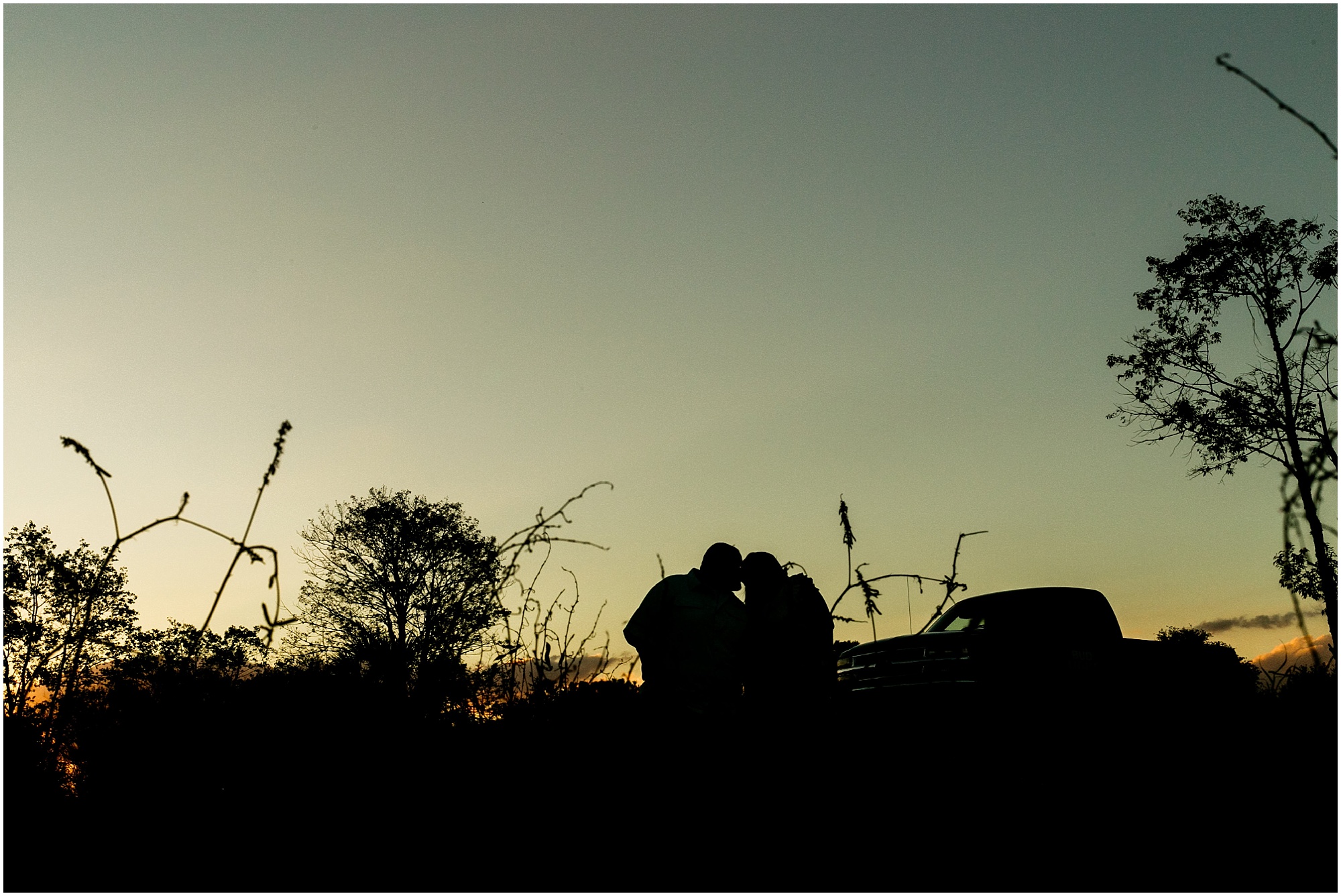 A sunset photo of the Monster Truck engagement session couple. 