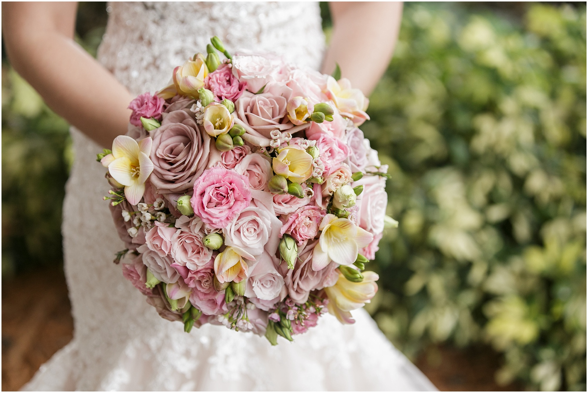 Classic shades of pink and blush floral wedding bouquet being held by the bride. 