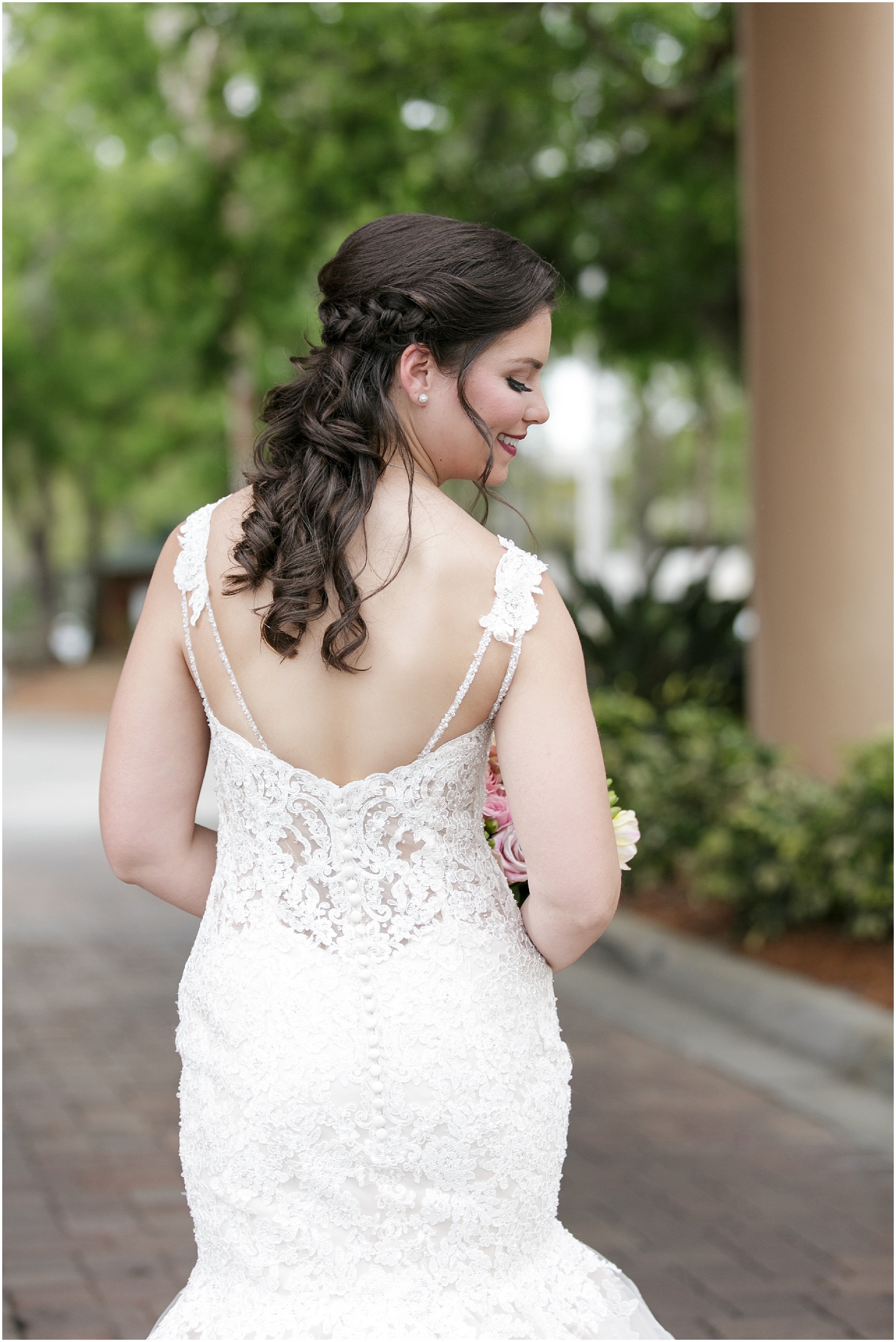 Bride showing off the back details of her wedding dress.