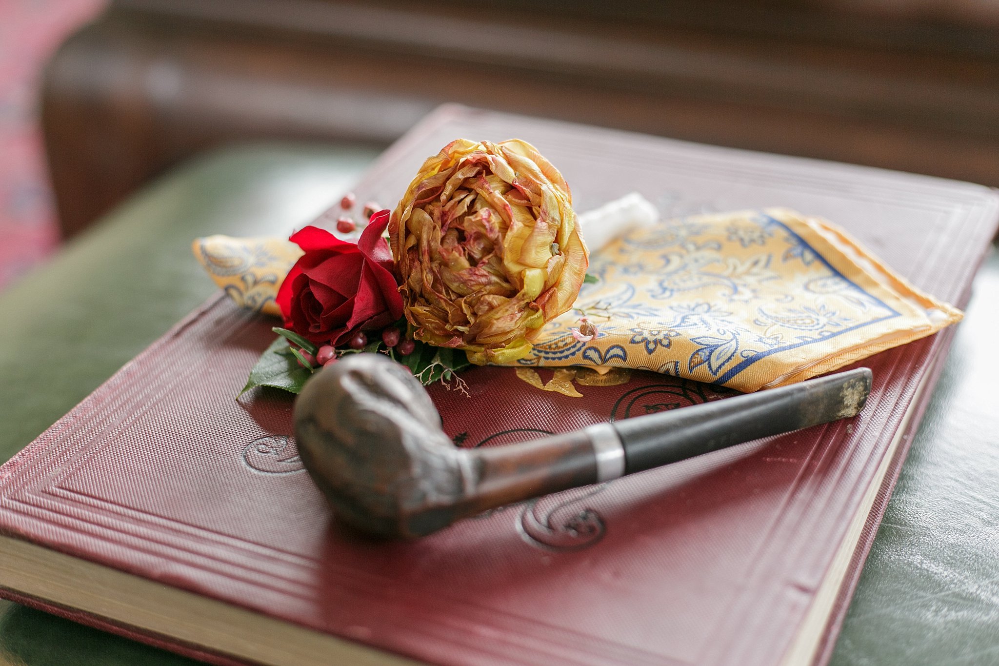 Groom accessories including a pipe, handkerchief, and boutonniere.