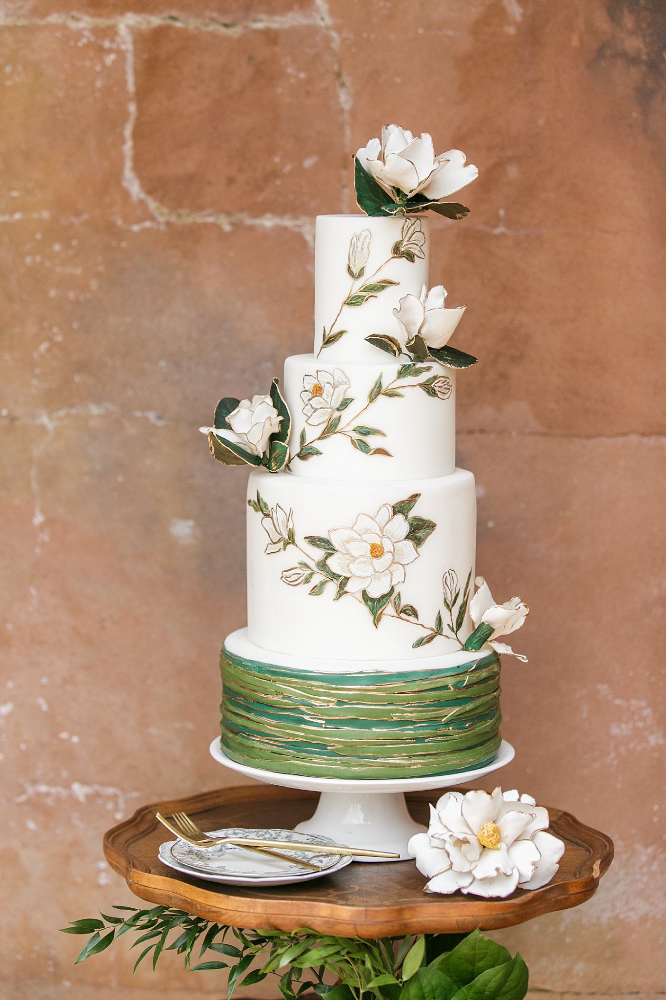 Vintage southern wedding cake with watercolor magnolia flowers.