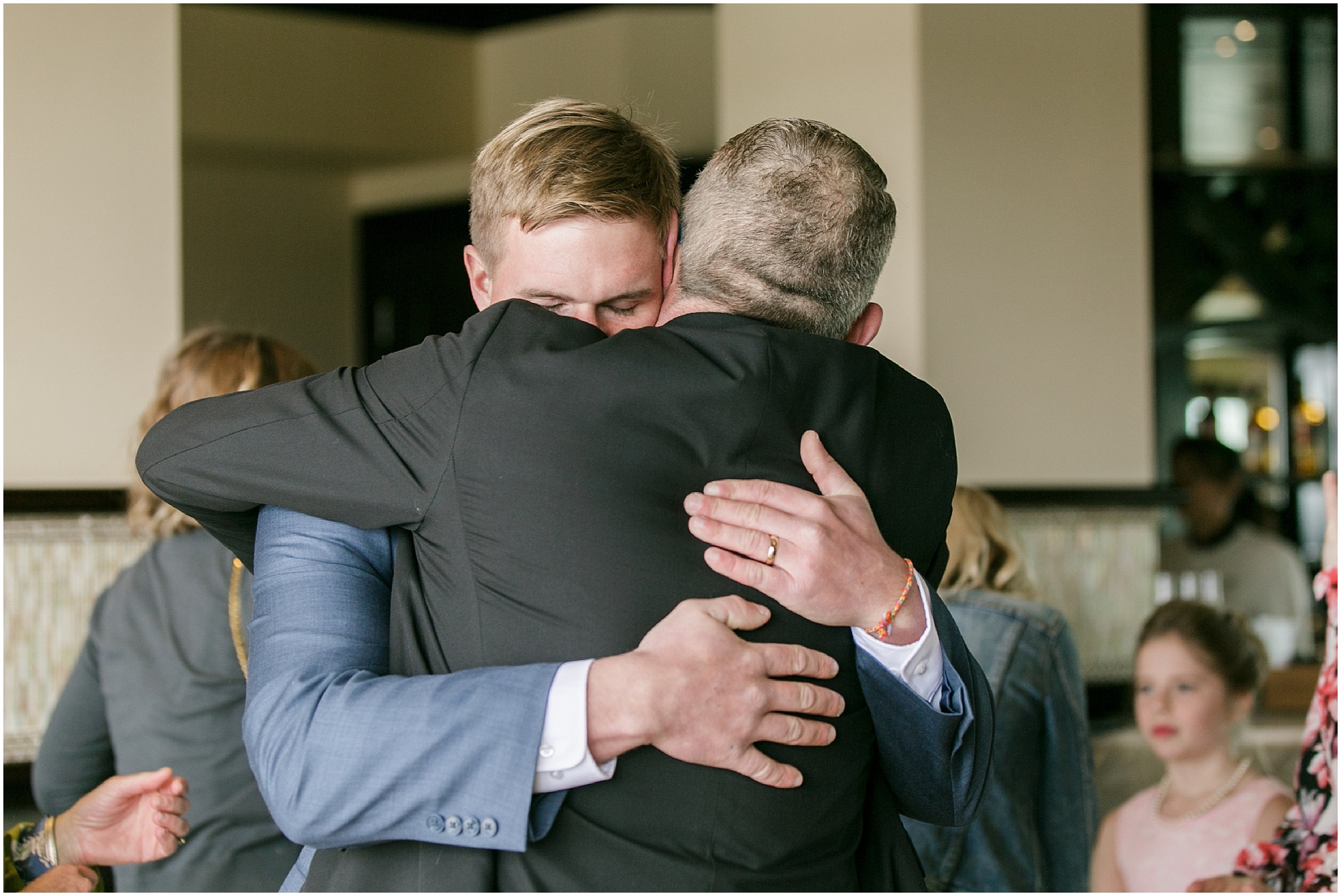 Groom gives his father in law a hug after wedding ceremony.