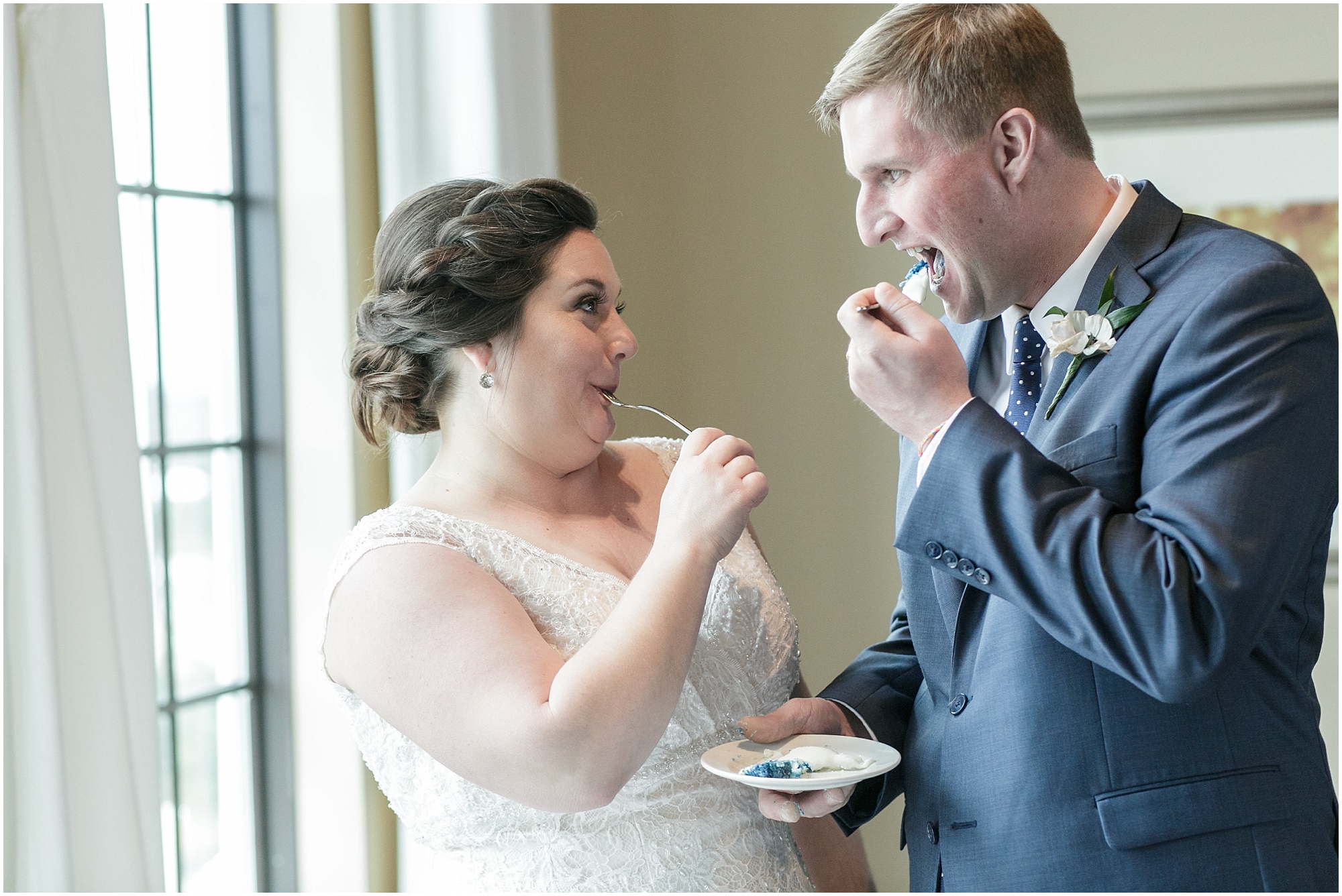 Bride and groom taste their wedding cake together. 
