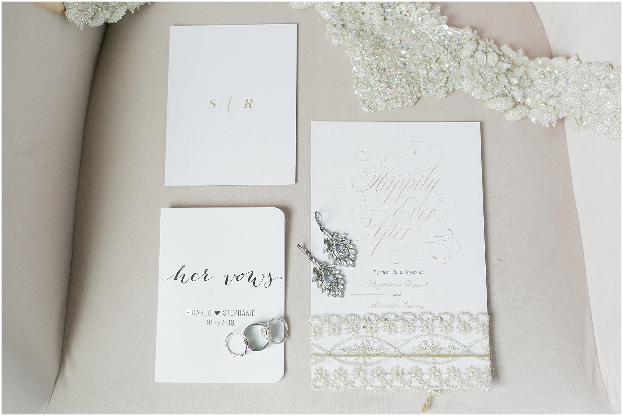 Happily ever after wedding invitation and vows along with some bridal jewelry.