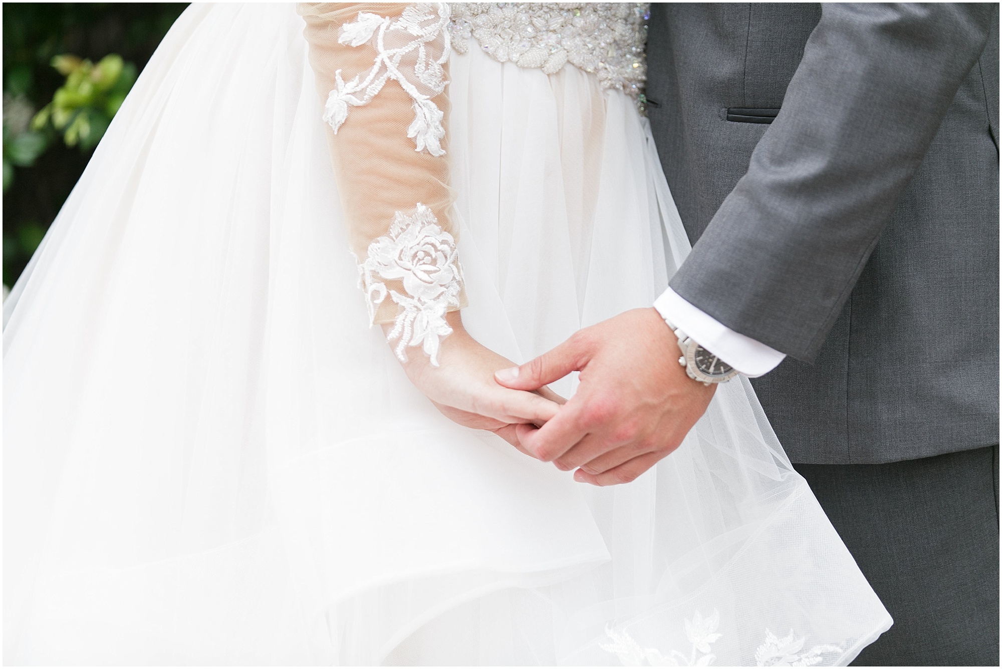 A close up picture of the bride and groom holding hands. 