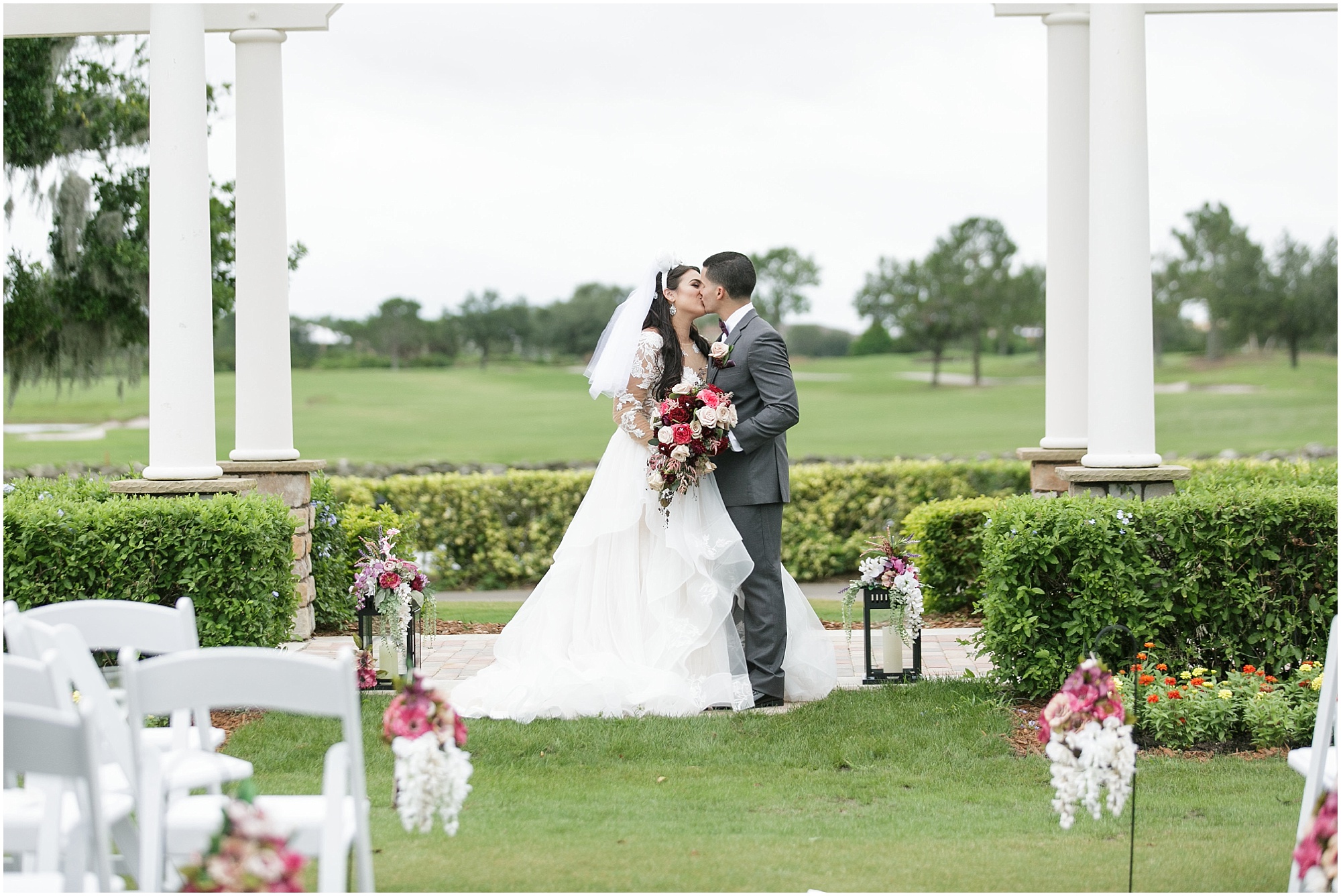 Bride and groom kiss in their ceremony space before wedding. 