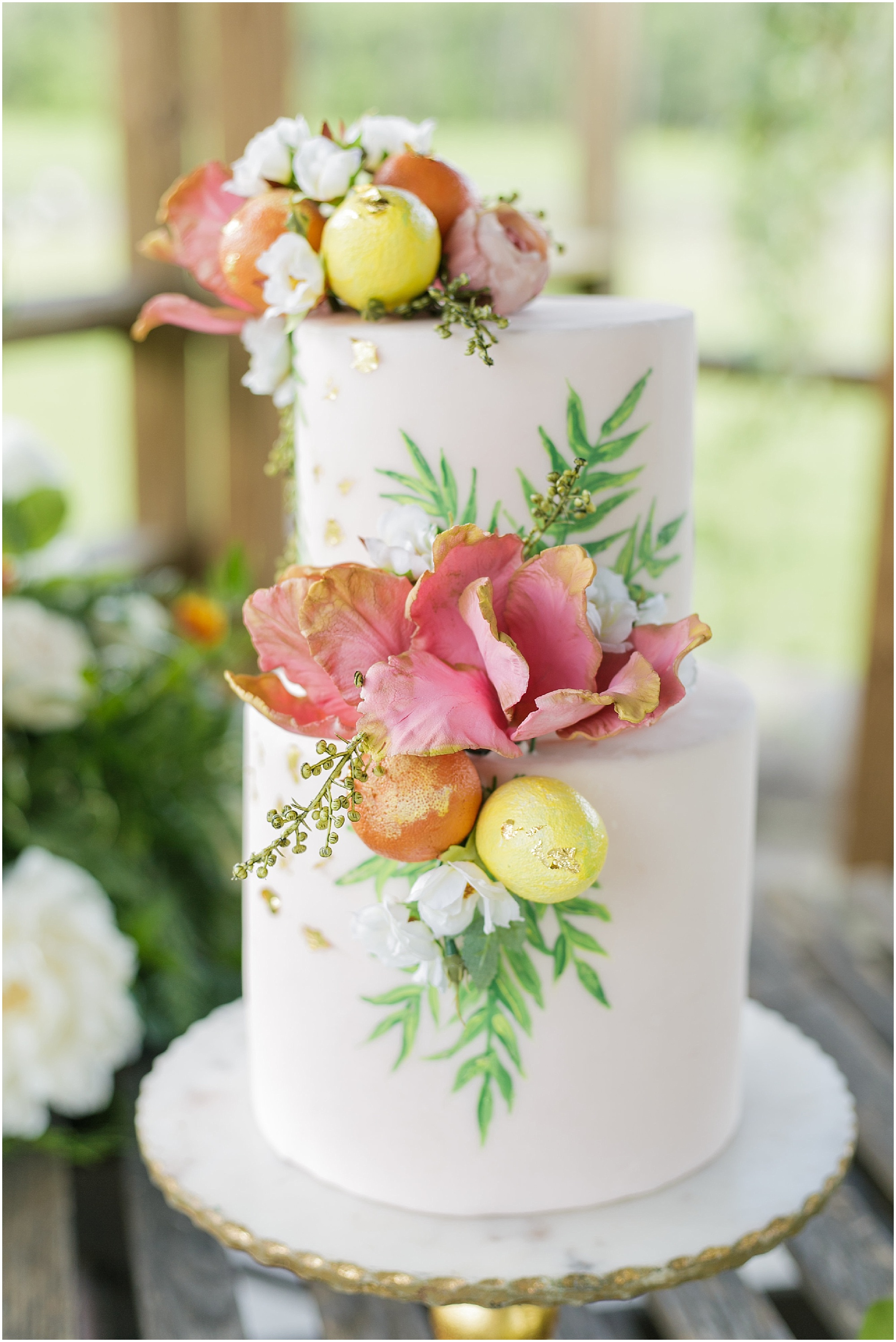 White wedding cake decorated with citrus and flowers. 