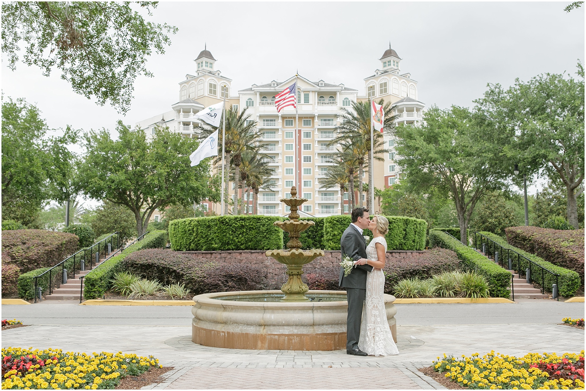 Bride and groom kiss while standing near the fountain at Reunion Resort. 