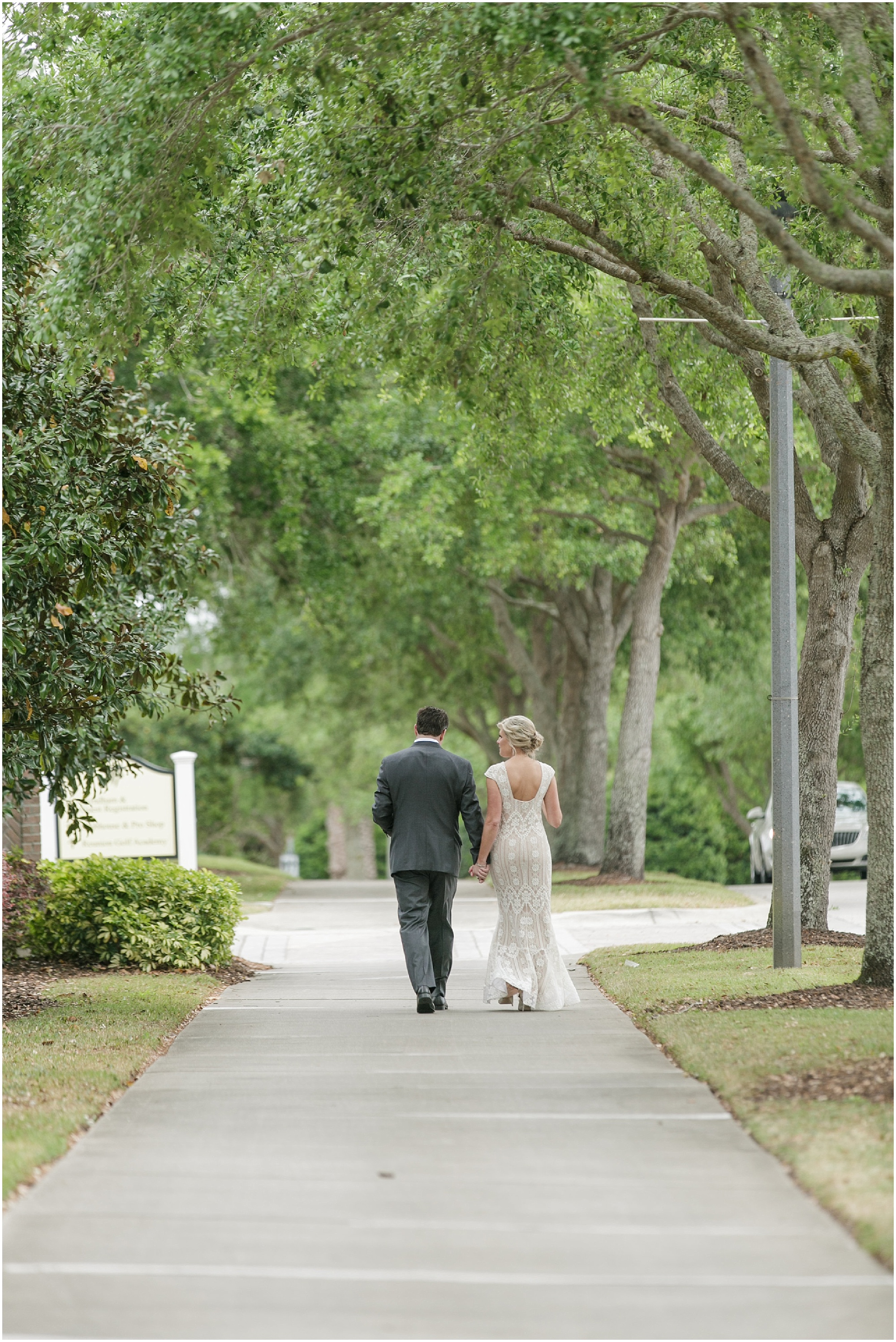 Bride and groom walking down the sidewalk and holding hands. 