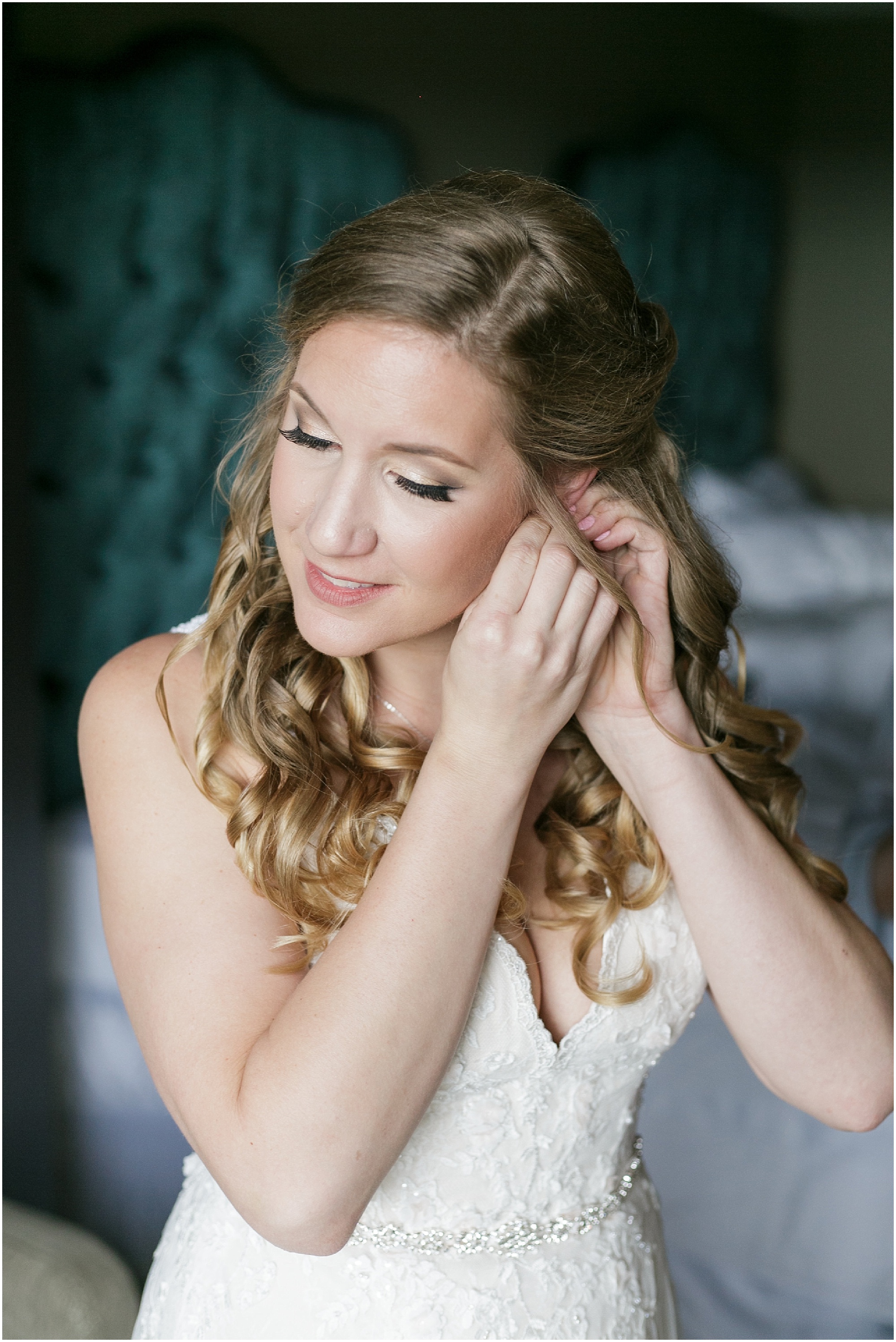 Bride putting on her right earring. 
