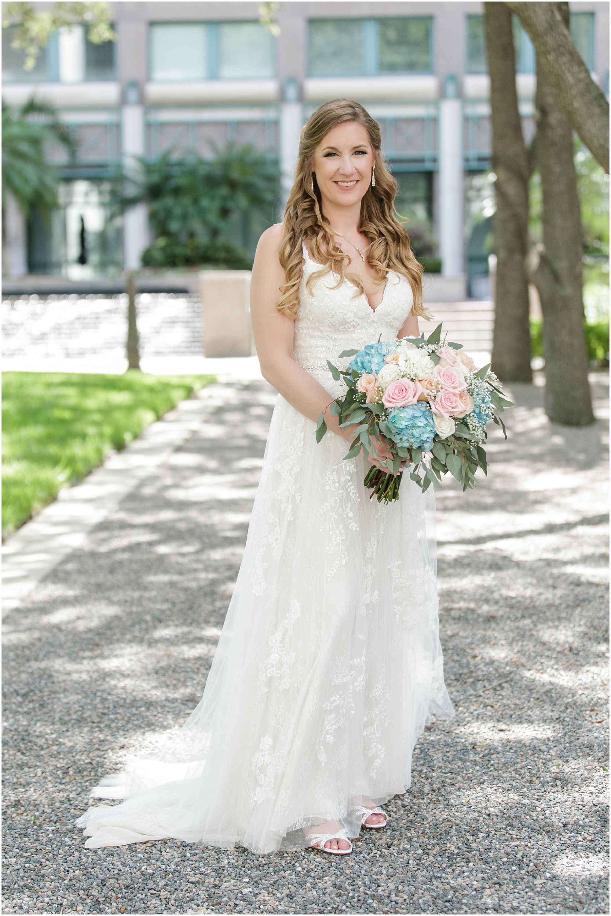 Full length portrait of the bride holding her colorful bouquet. 