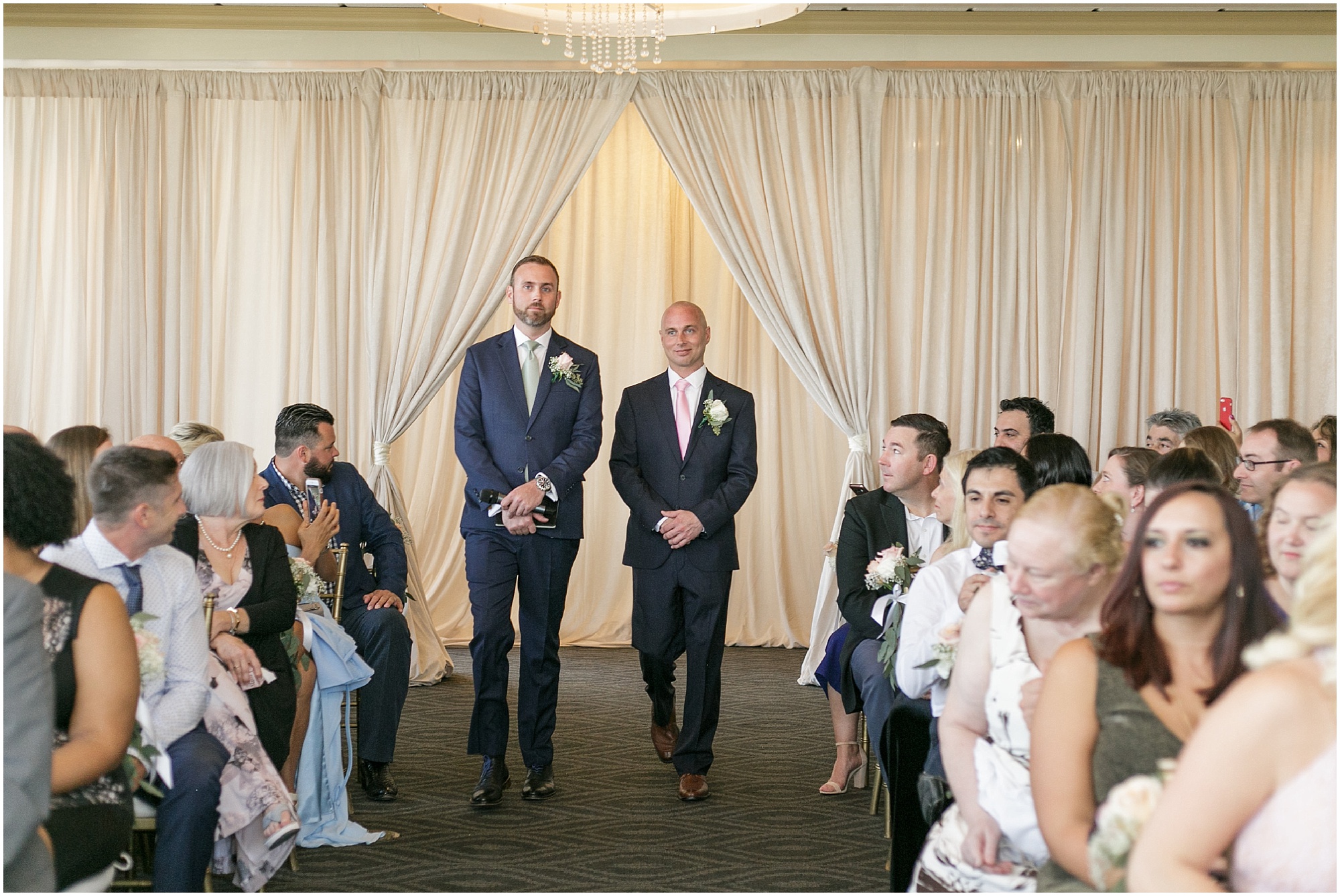 Groom walking down the aisle with the officiant. 