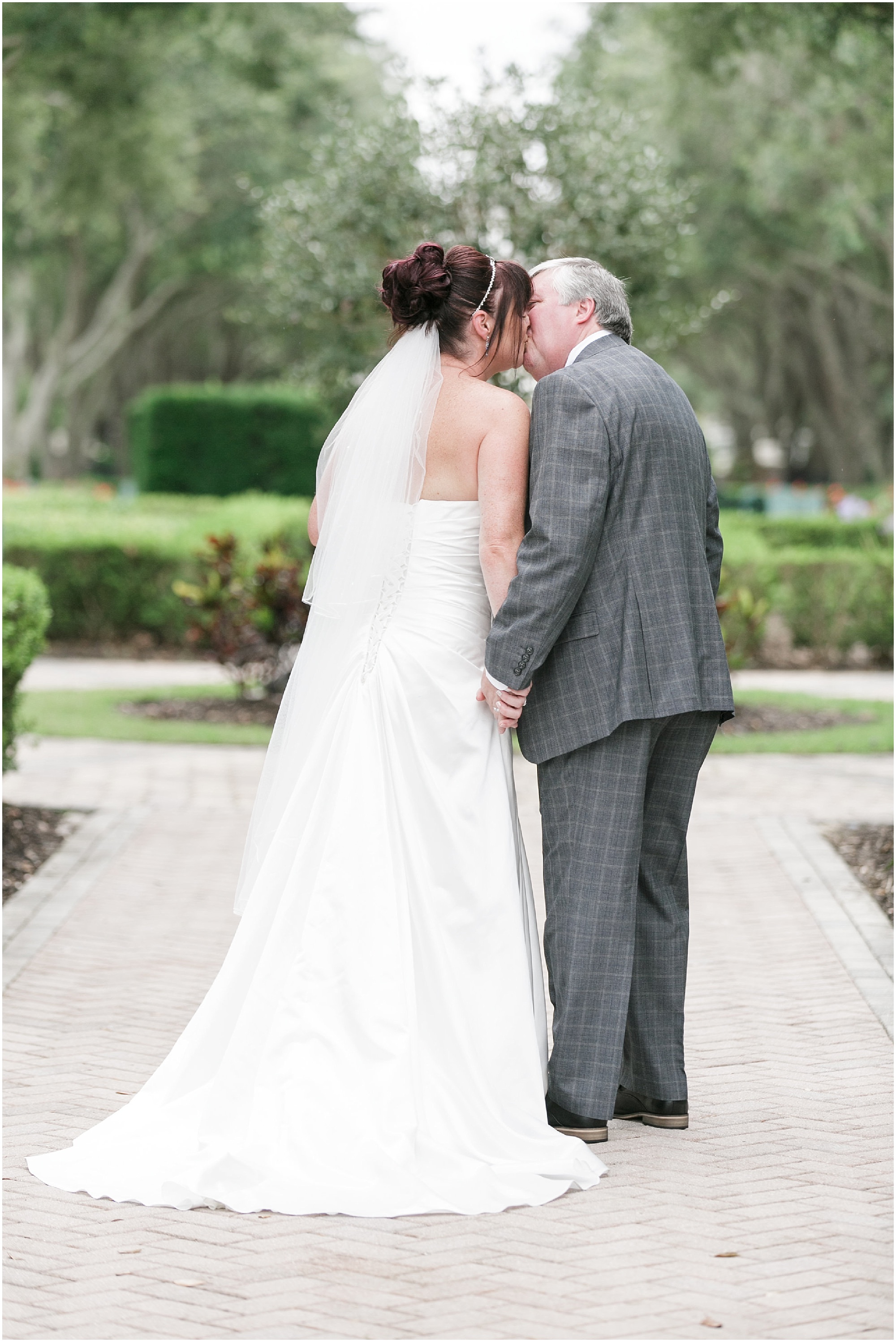 Romantic Weekend Brunch Wedding couple kissing while taking portraits in the courtyard of Reunion Resort in Orlando