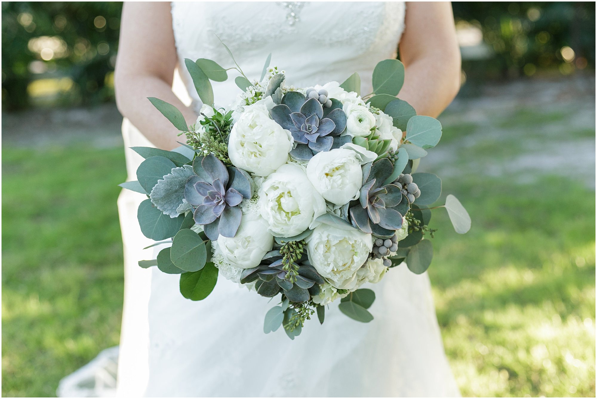 Close up of the brides succulent and white flower wedding bouquet. 