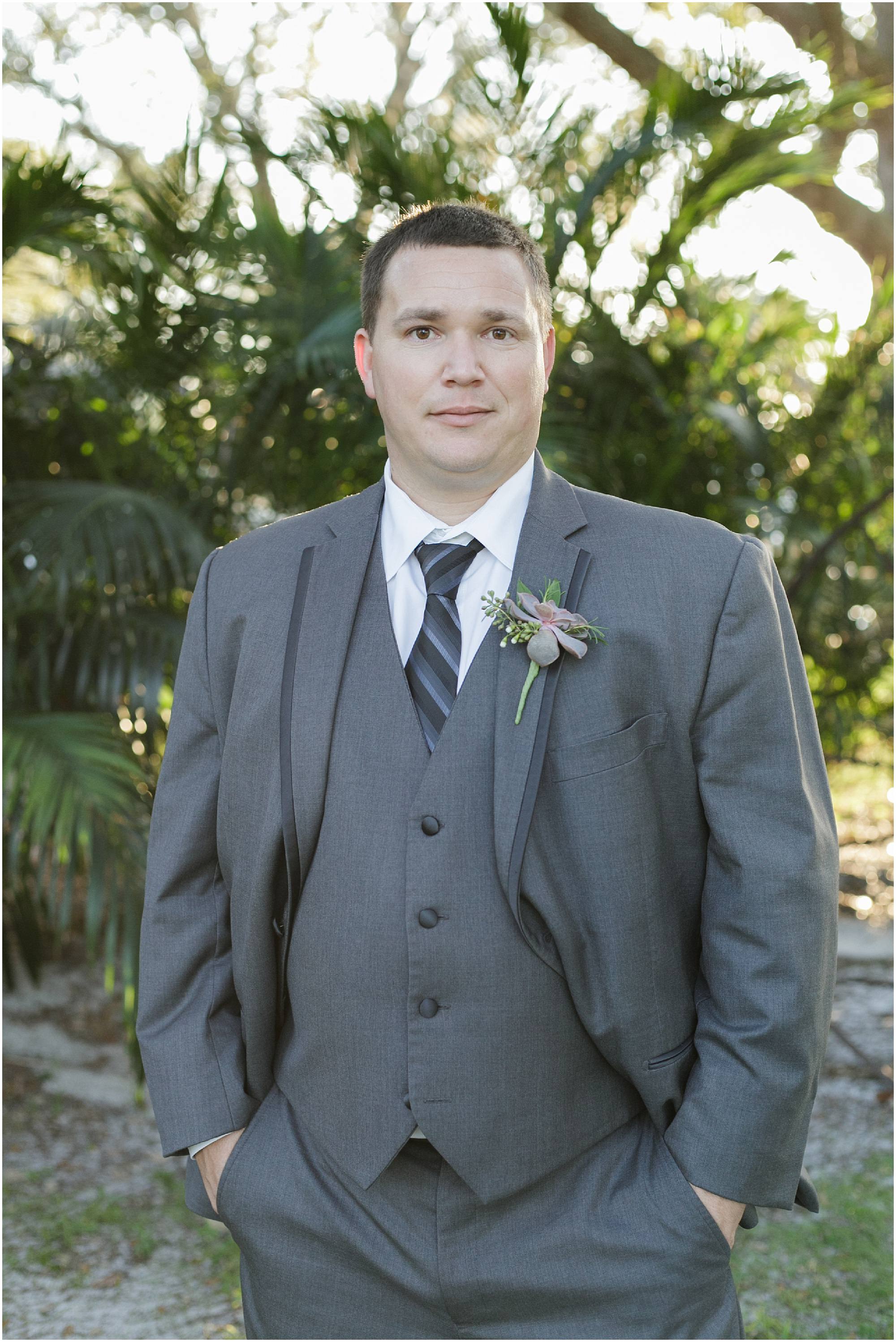 Portrait of the groom in a gray suit. 