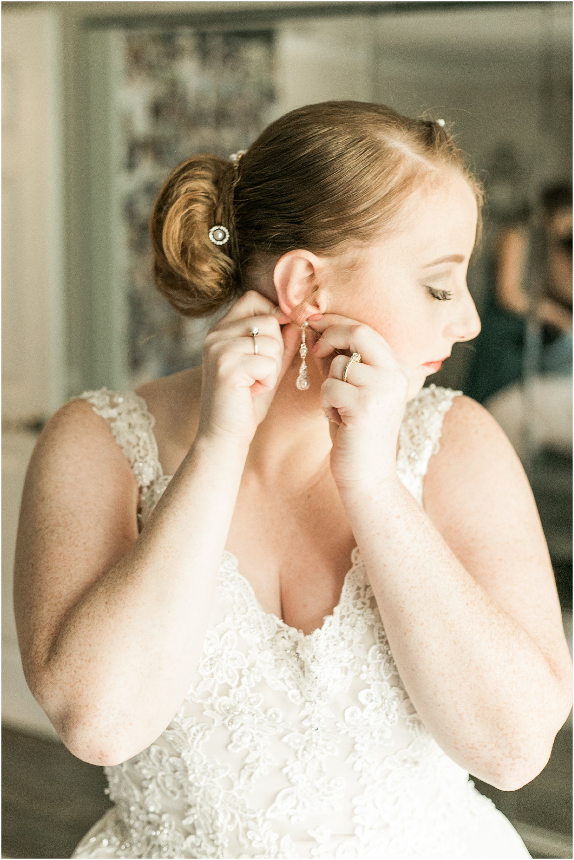 Bride putting her earrings on