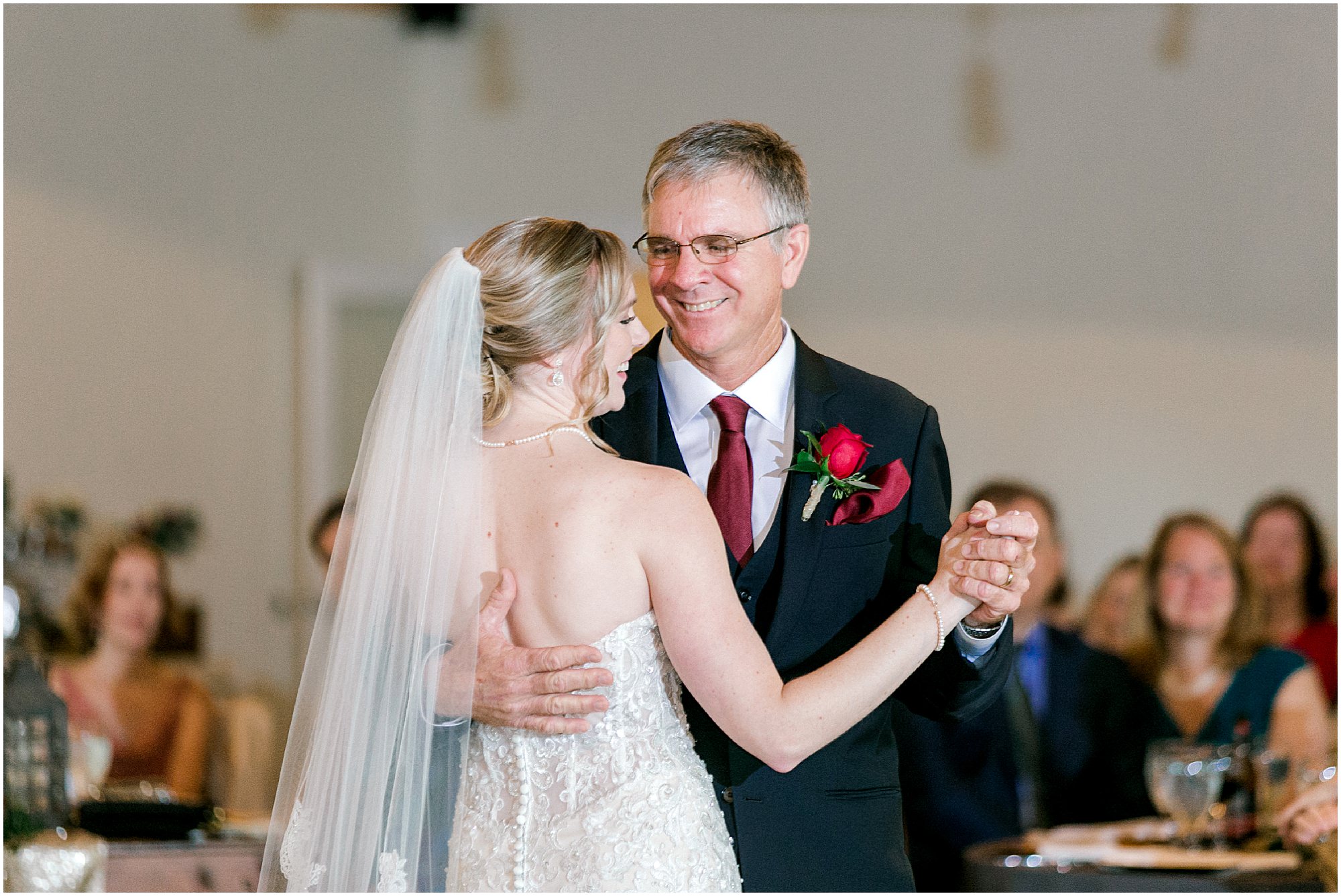 Bride and her father smiling as they dance together