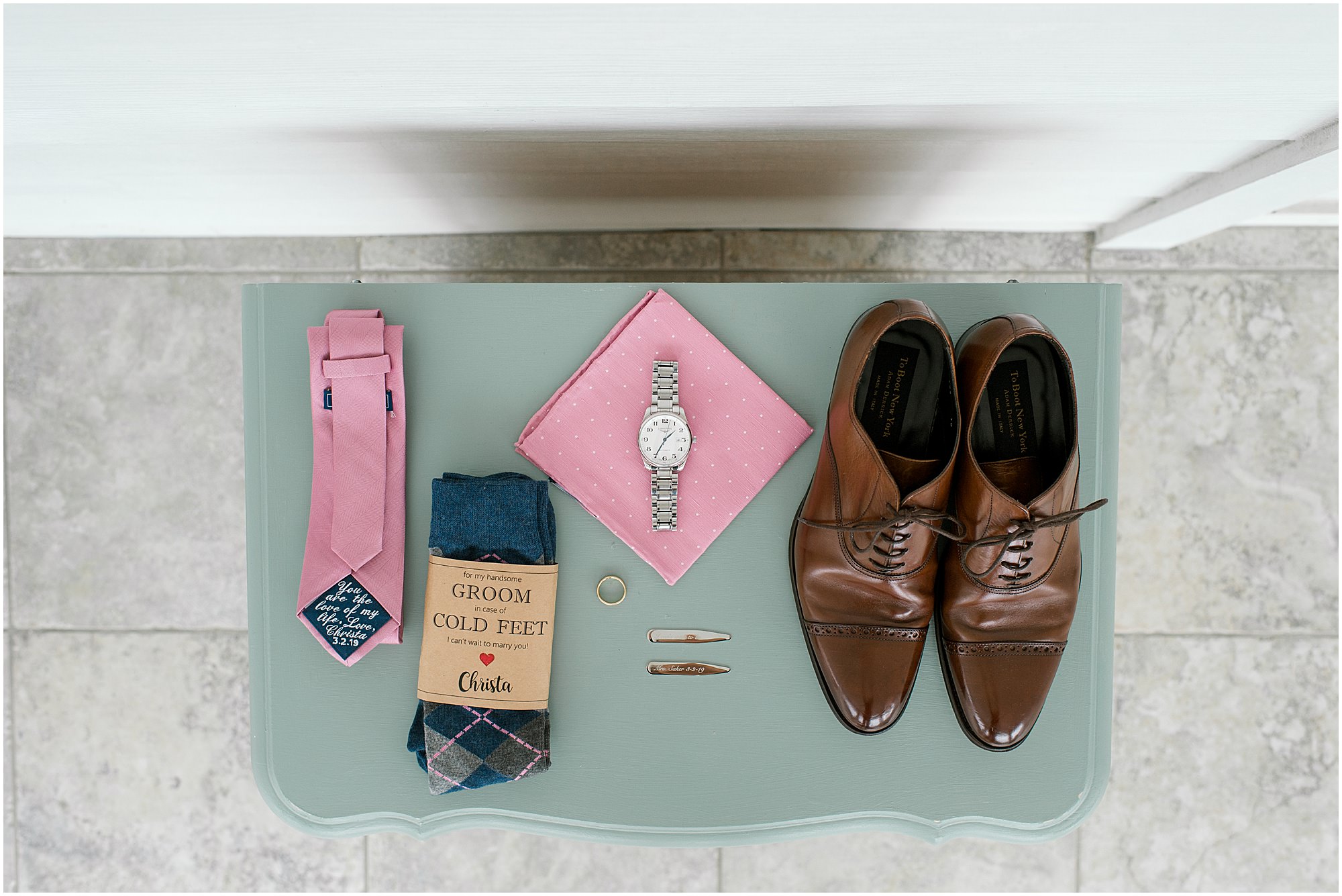 Groom's details like pink tie, brown shoes, and other accessories for dreamy wedding