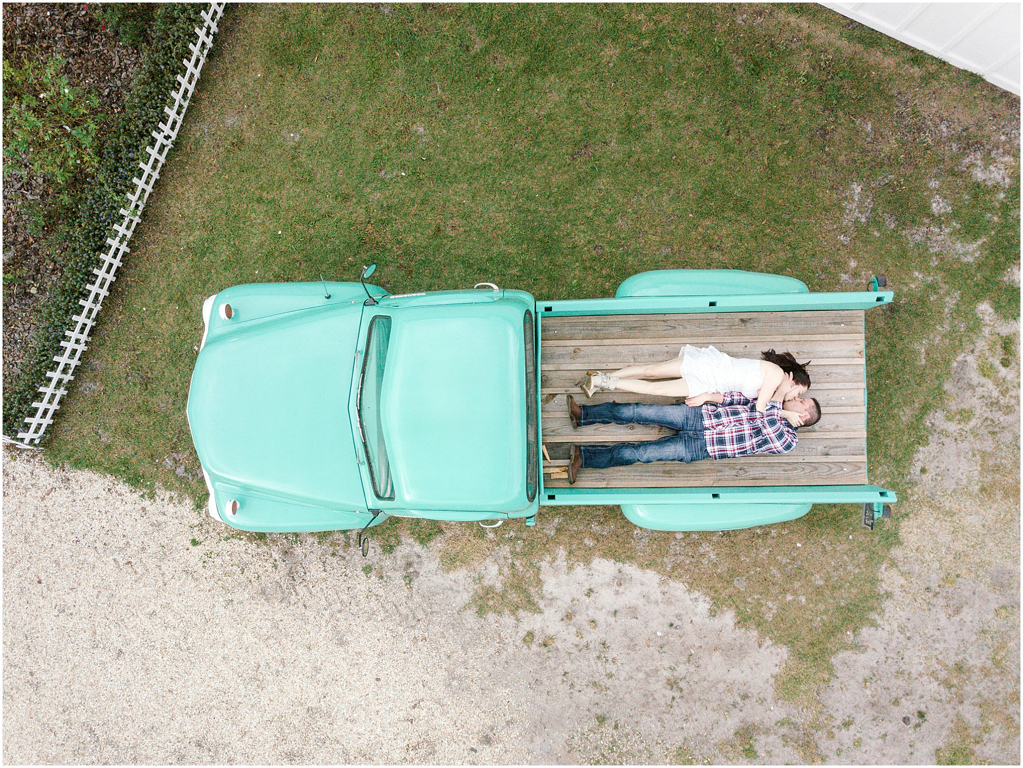Overhead photo of a couple laying in the bed of an antique pickup truck at Ever After Farms.